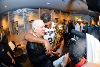 SAN ANTONIO, TX - JUNE 15: Head Coach Gregg Popovich and Tim Duncan #21 of the San Antonio Spurs celebrate in the locker room with the Larry O'Brien trophy after defeating the Miami Heat to win the 2014 NBA Finals in Game Five of the 2014 NBA Finals on Ju