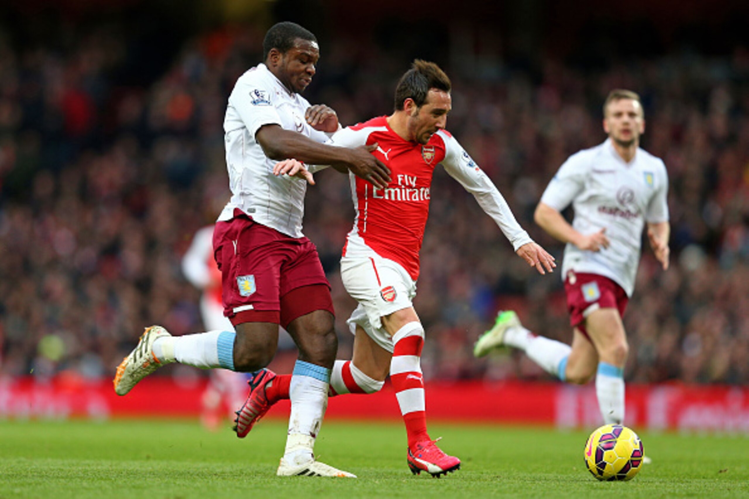 LONDON, ENGLAND - FEBRUARY 01:  Santi Cazorla of Arsenal holds off the challenge from Jores Okore of Aston Villa during the Barclays Premier League match between Arsenal and Aston Villa at the Emirates Stadium on February 1, 2015 in London, England.  (Pho