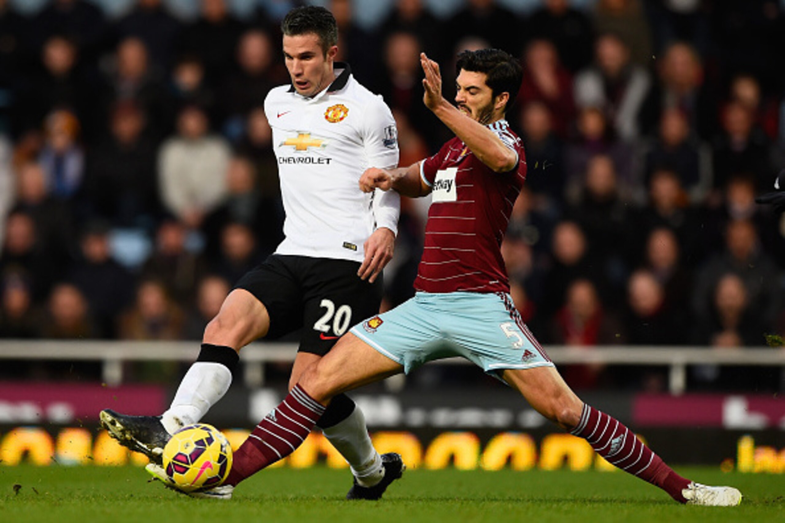 LONDON, ENGLAND - FEBRUARY 08:  James Tomkins of West Ham tackles Robin van Persie of Manchester United during the Barclays Premier League match between West Ham United and Manchester United at Boleyn Ground on February 8, 2015 in London, England.  (Photo