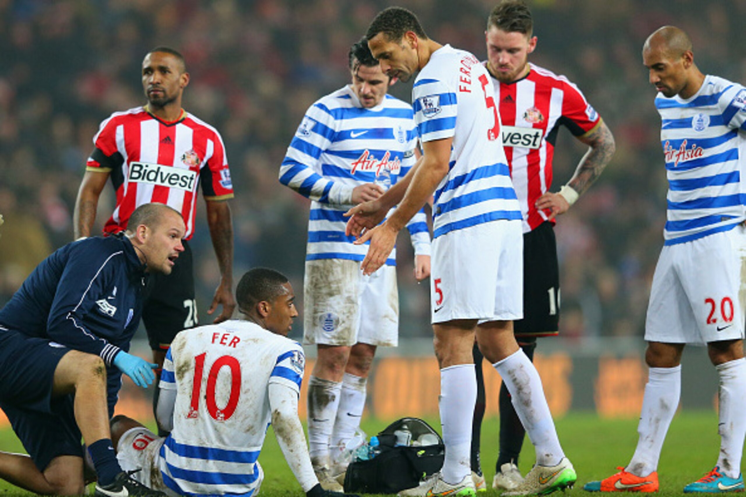 SUNDERLAND, ENGLAND - FEBRUARY 10:  Rio Ferdinand of QPR speaks to injured Leroy Fer of QPR as he receives treatment during the Barclays Premier League match between Sunderland and Queens Park Rangers at Stadium of Light on February 10, 2015 in Sunderland