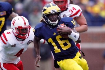 ANN ARBOR, MI - NOVEMBER 19:  Denard Robinson #16 of the Michigan Wolverines tries to out run the tackle of Lavonte David #4 of the Nebraska Cornhuskers at Michigan Stadium on November 19, 2011 in Ann Arbor, Michigan. Michigan won the game 45-17. (Photo b