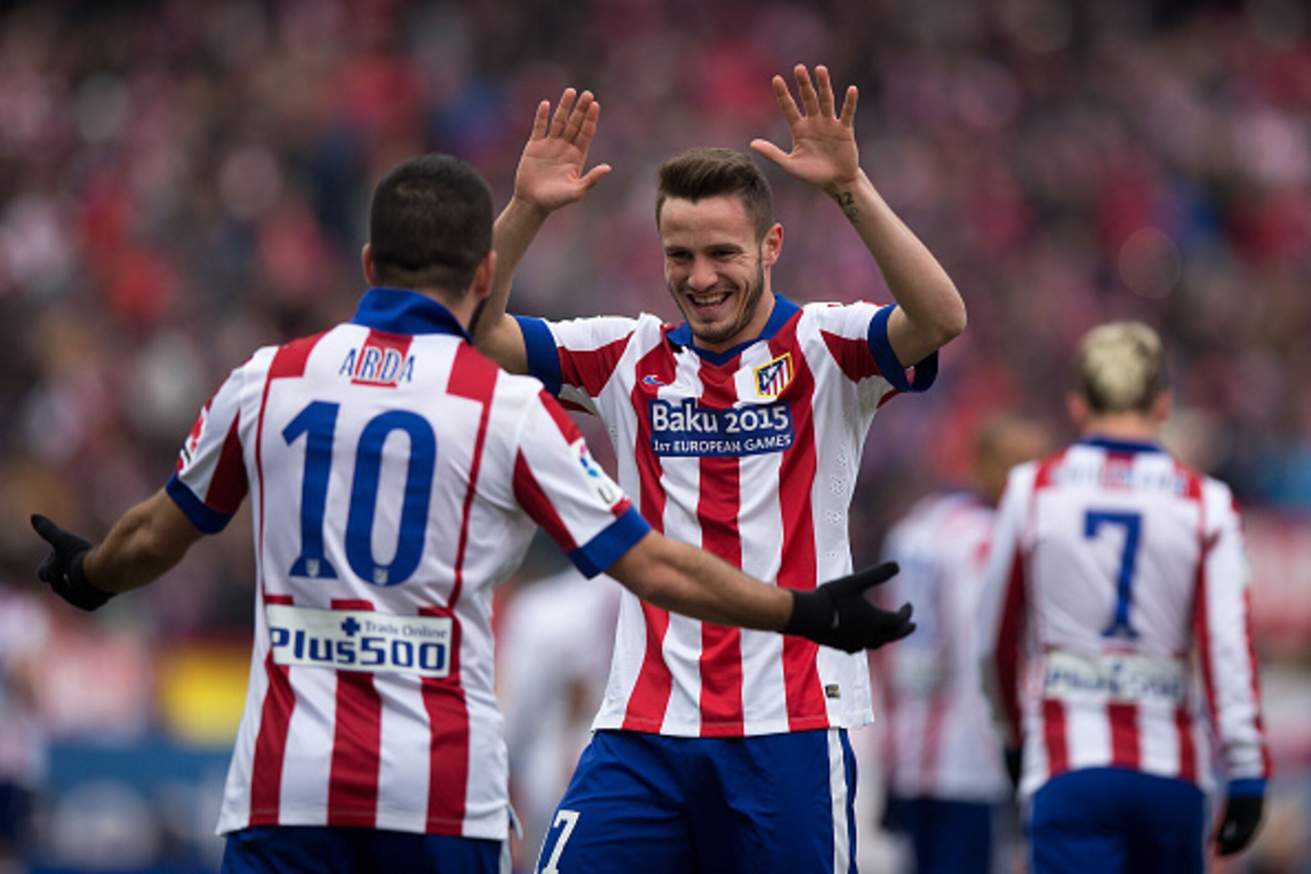 MADRID, SPAIN - FEBRUARY 07:  Saul Niguez (R) of Atletico de Madrid celebrates scoring their second goal with teammate Arda Turan (L) during the La Liga match between Club Atletico de Madrid and Real Madrid CF at Vicente Calderon Stadium on February 7, 20