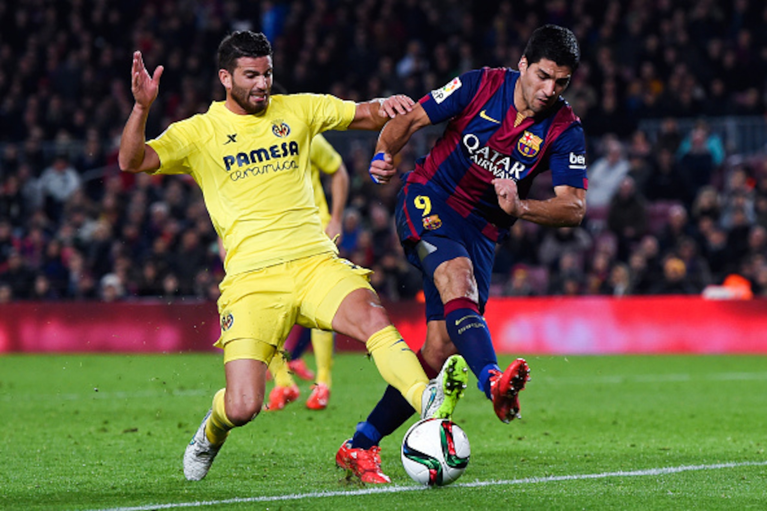 BARCELONA, SPAIN - FEBRUARY 11:  Luis Suarez of FC Barcelona competes for the ball with Mateo Musacchio of Villarreal CF during the Copa del Rey Semi-Final first leg match between FC Barcelona and Villarreal CF at Camp Nou on February 11, 2015 in Barcelon