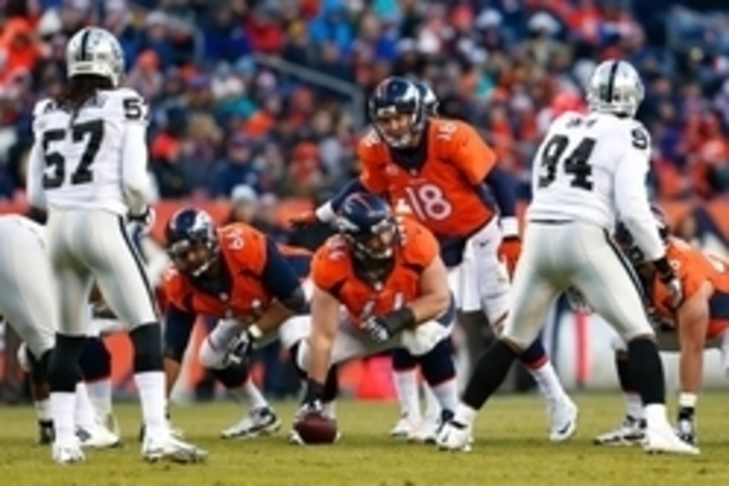 Dec 28, 2014; Denver, CO, USA; Denver Broncos quarterback Peyton Manning (18) lines up with center Will Montgomery (64) and center Manny Ramirez (66) in the third quarter against Oakland Raiders outside linebacker Ray-Ray Armstrong (57) and defensive tack