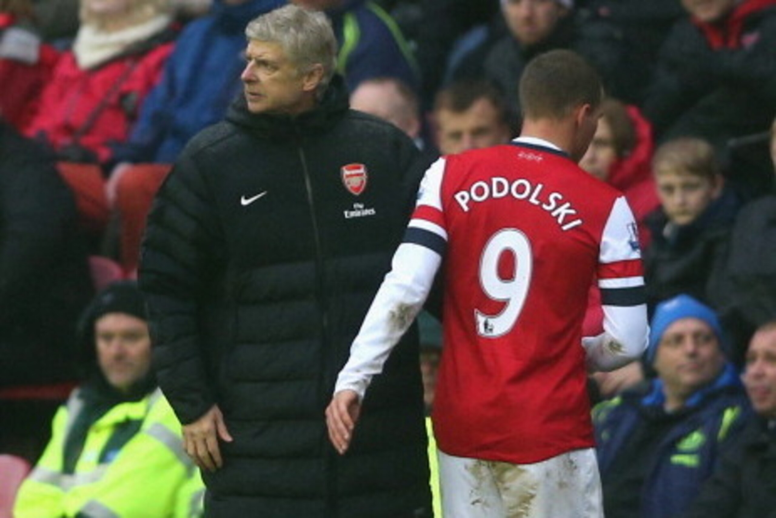 WIGAN, ENGLAND - DECEMBER 22:  Lukas Podolski of Arsenal is substituted as Arsenal Manager Arsene Wenger looks on during the Barclays Premier League match between Wigan Athletic and Arsenal at the DW Stadium on December 22, 2012 in Wigan, England.  (Photo