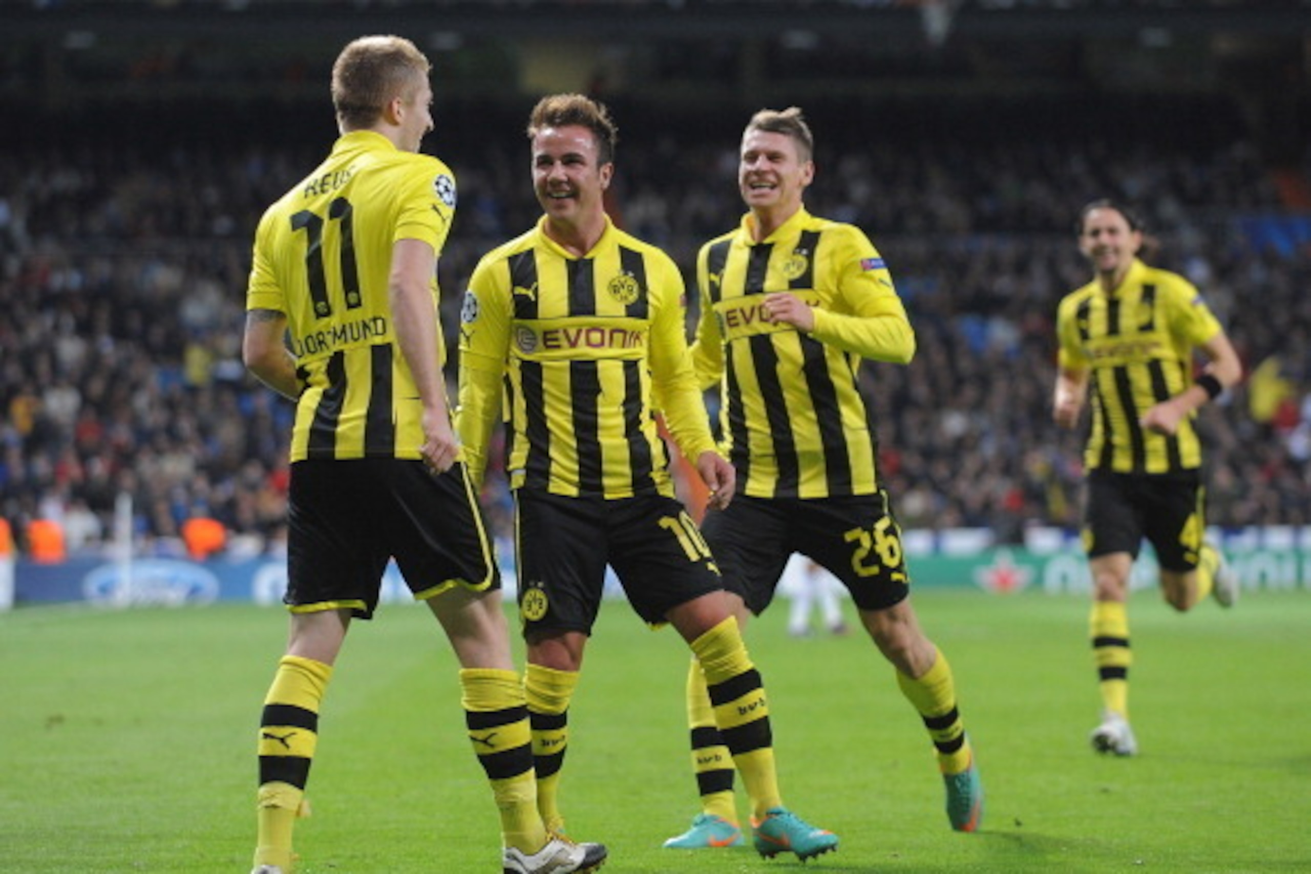 MADRID, SPAIN - NOVEMBER 06:  Marco Reus (L) of Borussia Dortmund  celebrates with team-mates Mario Gotze and Lukasz Piszczek after scoring Borussia's opening goal during the UEFA Champions League Group D match between Real Madrid and Borussia Dortmund at