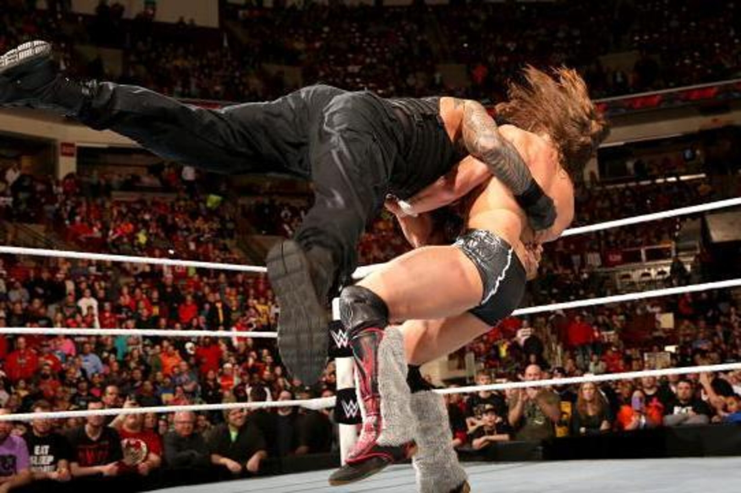 Roman Reigns attacks Daniel Bryan.