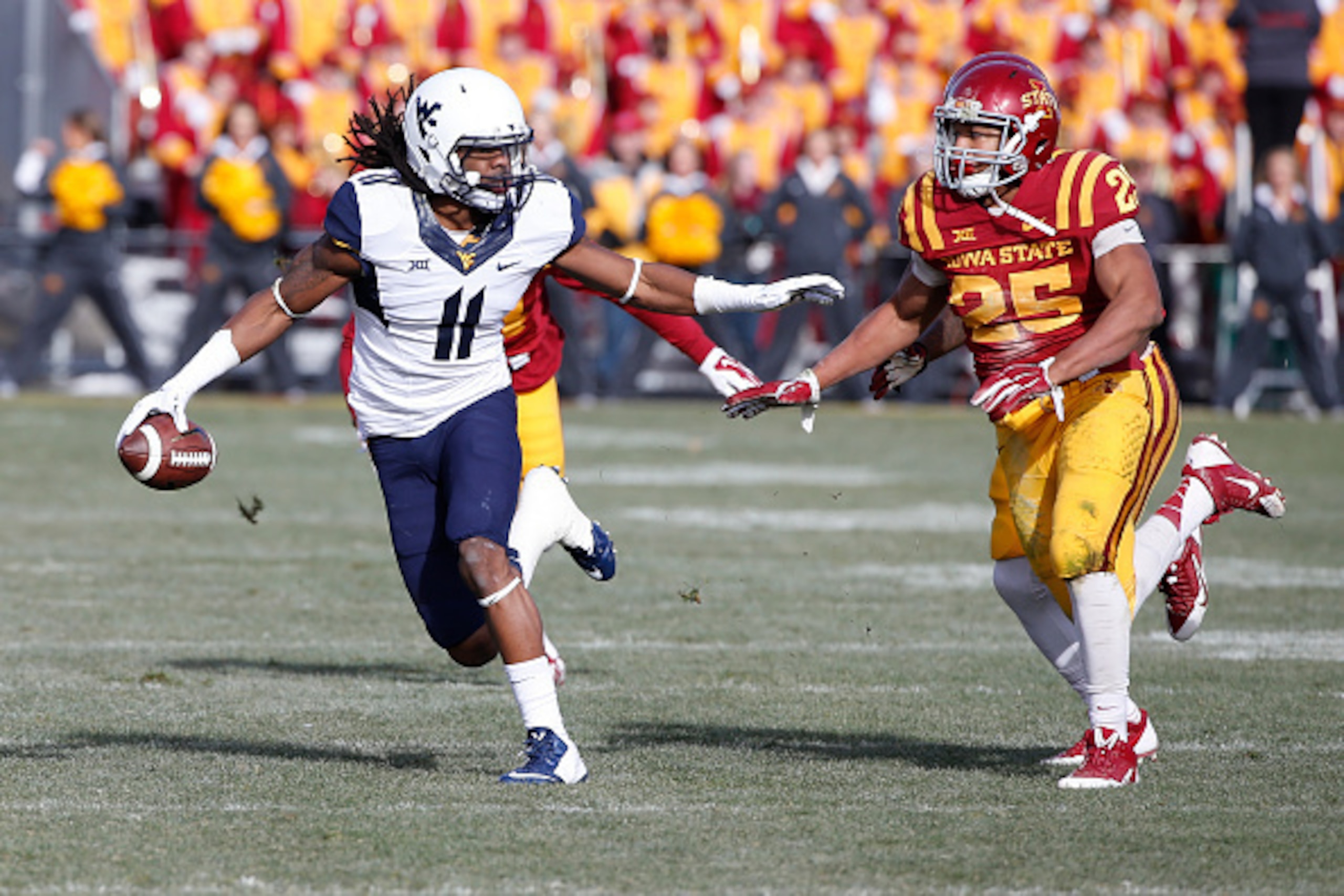 AMES, IA - NOVEMBER 29: Wide receiver Kevin White #11 of the West Virginia Mountaineers rushes for yards past linebacker Brian Mills #25 of the Iowa State Cyclones in the first half of play at Jack Trice Stadium on November 29, 2014 in Ames, Iowa. The Wes