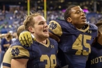 Sep 13, 2014; Indianapolis, IN, USA; Notre Dame Fighting Irish linebacker Joe Schmidt (38) and linebacker Romeo Okwara (45) sing the Alma Mater after Notre Dame defeated the Purdue Boilermakers 30-14 at Lucas Oil Stadium. Mandatory Credit: Matt Cashore-US
