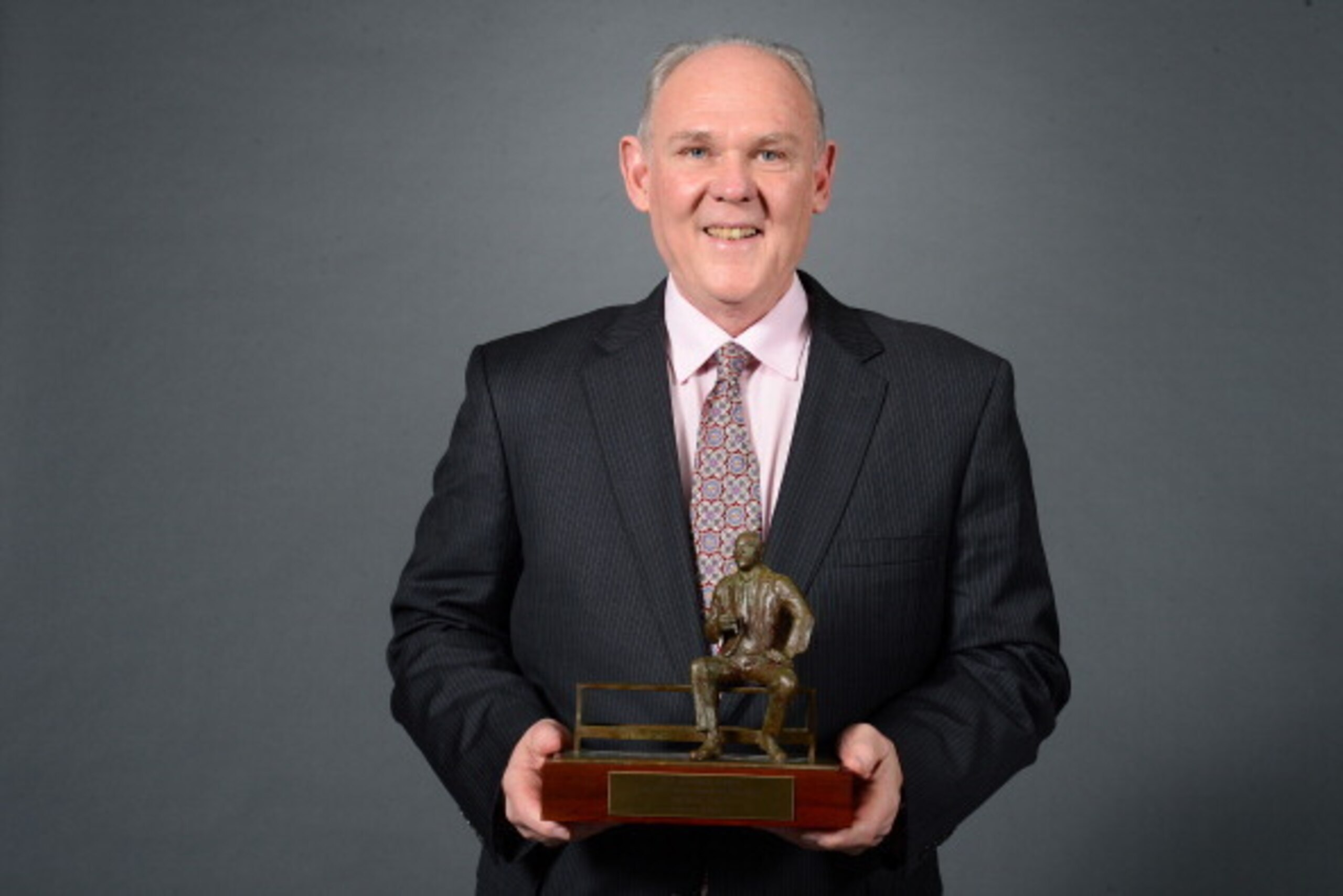 DENVER, CO - MAY 8:  Head Coach George Karl of the Denver Nuggets poses for a photo with the Red Auerbach Trophy after being named 2012-2013 NBA Coach of the Year on May 8, 2013 at the Pepsi Center in Denver, Colorado. NOTE TO USER: User expressly acknowl