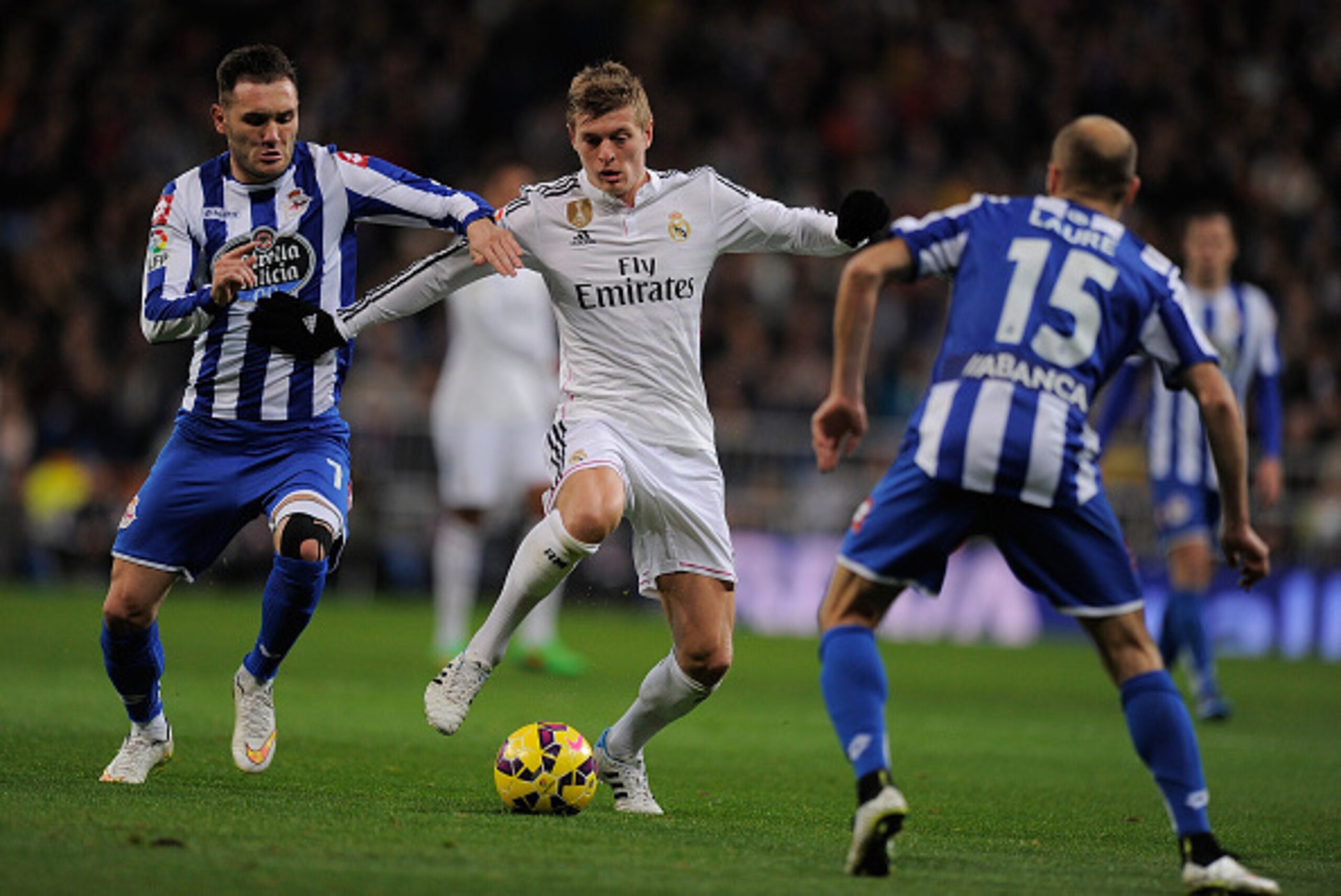 MADRID, SPAIN - FEBRUARY 15:  Toni Kroos of Real Madrid is tackled by Lucas Perez of  RC Deportivo La Coruna during the La Liga match between Real Madrid CF and RC Deportivo La Coruna at Estadio Santiago Bernabeu on February 15, 2015 in Madrid, Spain.  (P