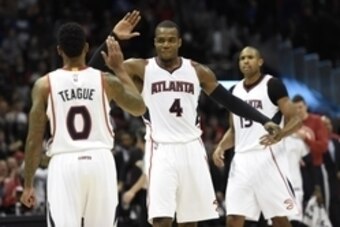 Jan 23, 2015; Atlanta, GA, USA; Atlanta Hawks guard Jeff Teague (0) and forward Paul Millsap (4) react late in the game as the Hawks win their team record 15th consecutive game against the Oklahoma City Thunder at Philips Arena. The Hawks defeated the Thu