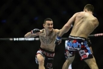 Feb 14, 2015; Broomfield, CO, USA; Cole Miller (blue) and Max Holloway (red) compete during the UFC Fight Night at the 1stBANK Center. Mandatory Credit: Ron Chenoy-USA TODAY Sports