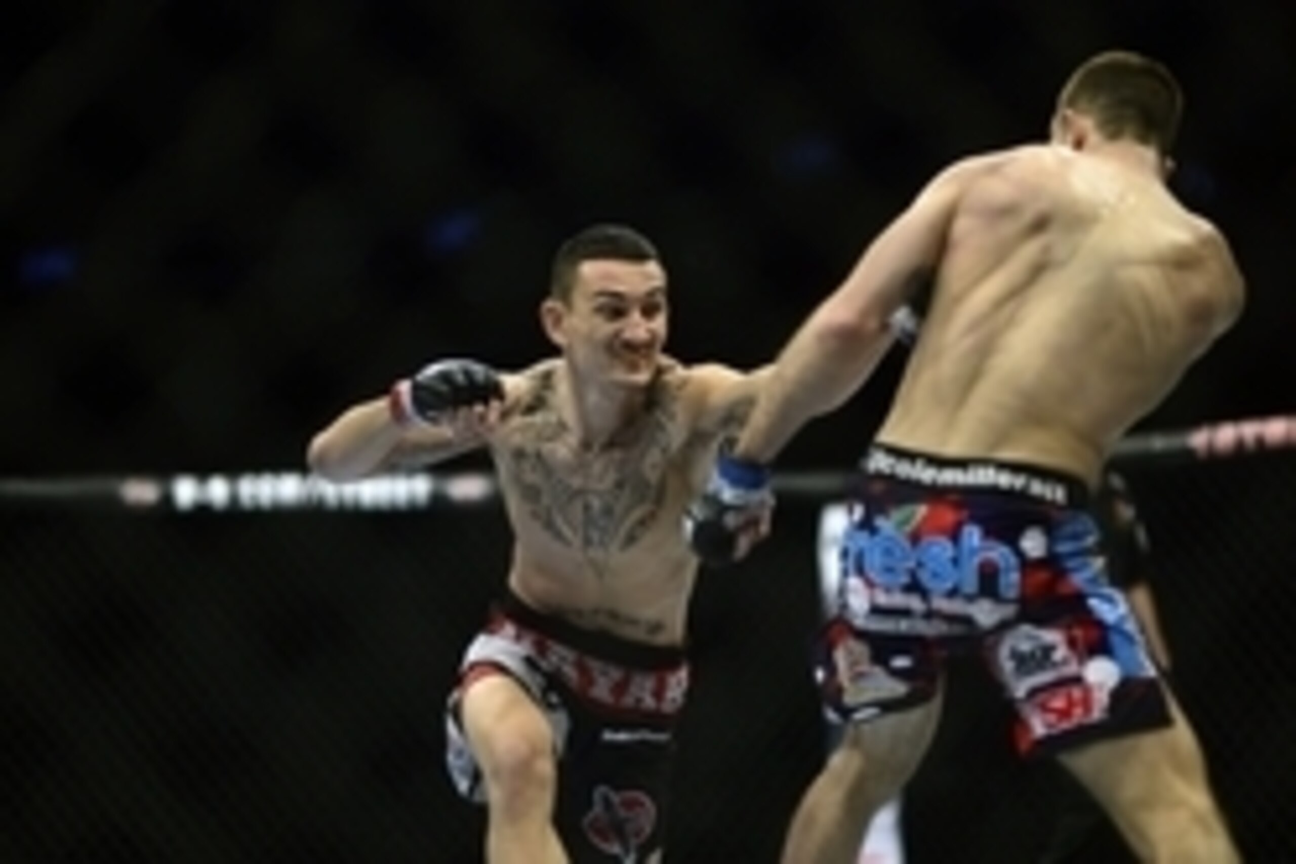 Feb 14, 2015; Broomfield, CO, USA; Cole Miller (blue) and Max Holloway (red) compete during the UFC Fight Night at the 1stBANK Center. Mandatory Credit: Ron Chenoy-USA TODAY Sports