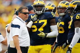 ANN ARBOR, MI - SEPTEMBER 20:  Head coach Brady Hoke talks with Frank Clark #57 during the first quarter while playing the Utah Utes on September 20, 2014 at Michigan Stadium in Ann Arbor, Michigan.  (Photo by Gregory Shamus/Getty Images)