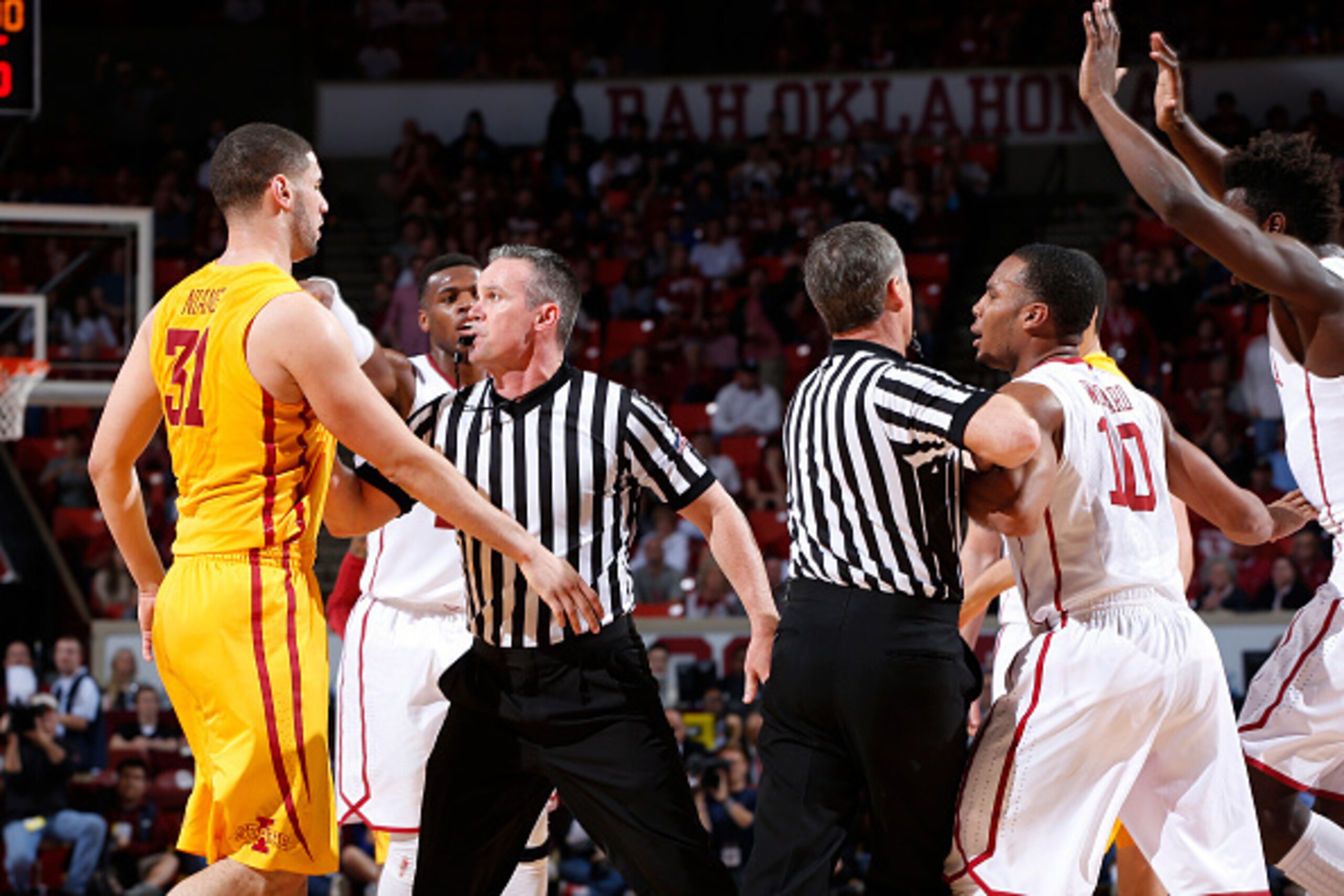 NORMAN, OK - FEBRUARY 9: Officials try to separate Georges Niang #31 of the Iowa State Cyclones and Jordan Woodard #10 of the Oklahoma Sooners after a scuffle during the game at Lloyd Noble Center on February 9, 2015 in Norman, Oklahoma. Oklahoma defeated