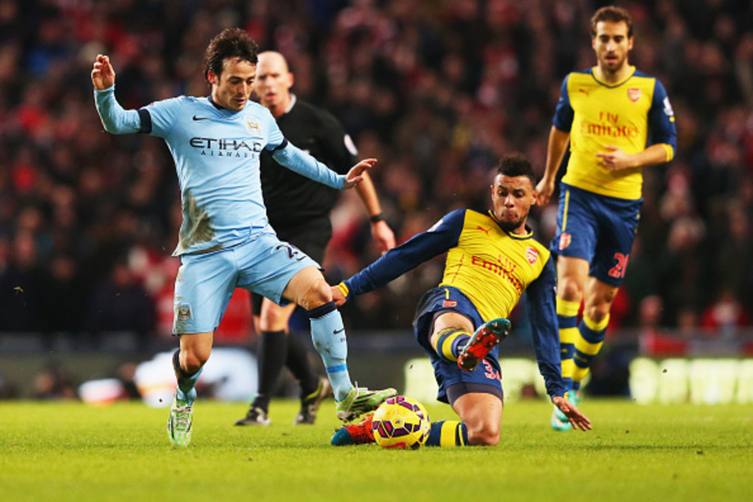 MANCHESTER, ENGLAND - JANUARY 18:  David Silva of Manchester City is tackled by Francis Coquelin of Arsenal during the Barclays Premier League match between Manchester City and Arsenal at Etihad Stadium on January 18, 2015 in Manchester, England.  (Photo 
