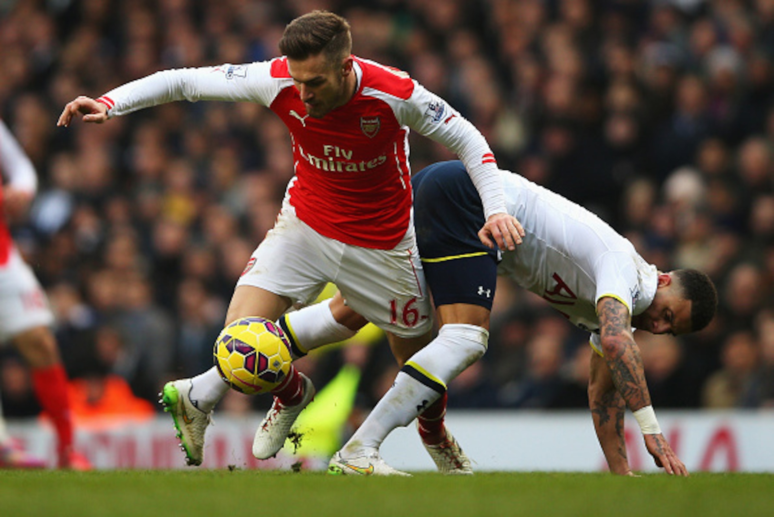 LONDON, ENGLAND - FEBRUARY 07: Aaron Ramsey of Arsenal tangles with Kyle Walker of Tottenham Hotspur during the Barclays Premier League match between Tottenham Hotspur and Arsenal at White Hart Lane on February 7, 2015 in London, England.  (Photo by Paul 