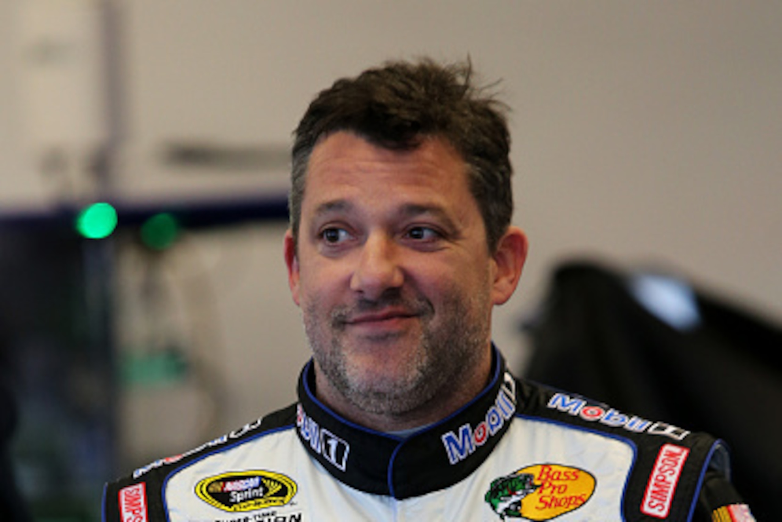 DAYTONA BEACH, FL - FEBRUARY 13: Tony Stewart, driver of the #14 Mobil 1/Bass Pro Shops Chevrolet, stands in the garage area during practice for the NASCAR Sprint Cup Series 3rd Annual Sprint Unlimited at Daytona International Speedway on February 13, 201