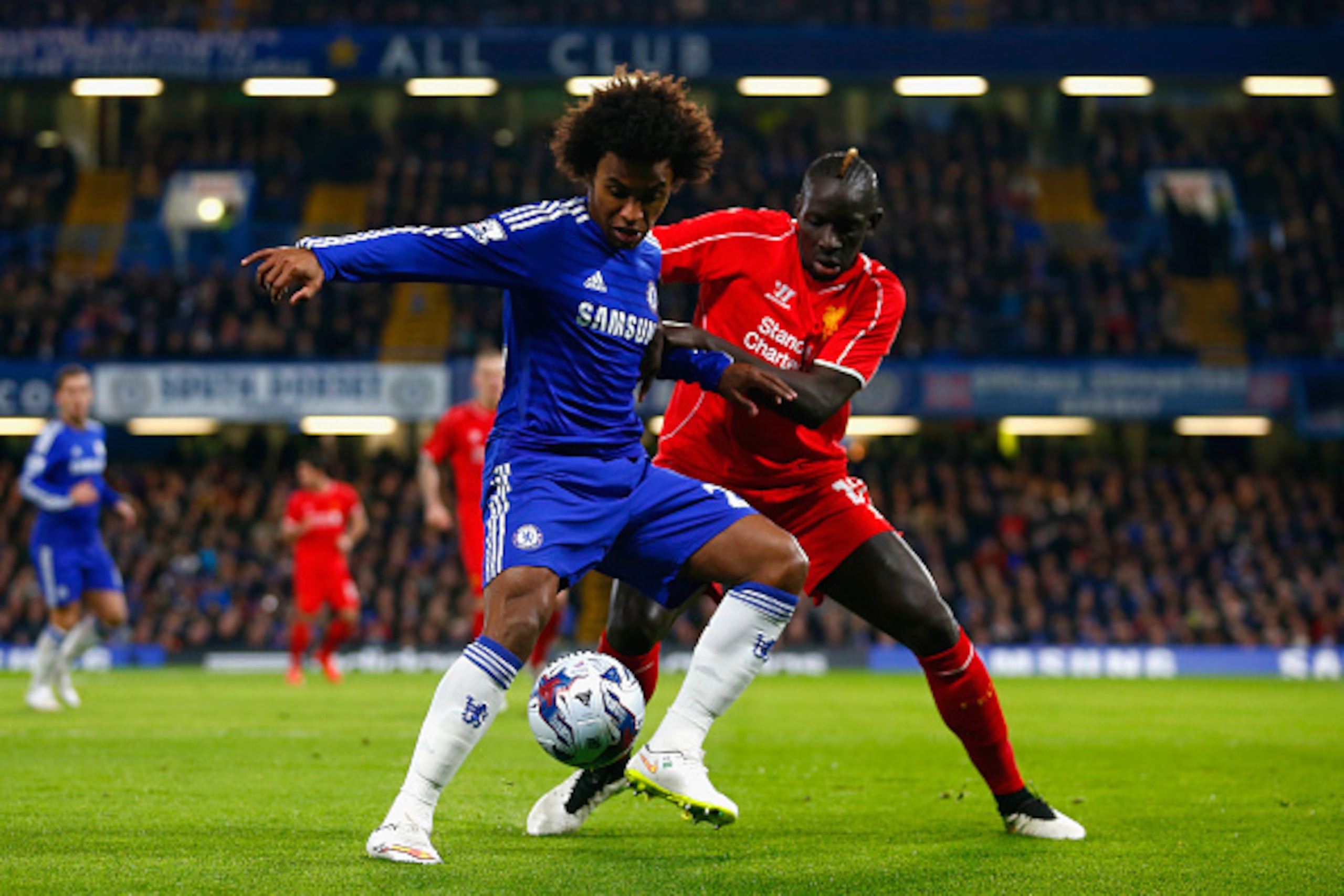LONDON, ENGLAND - JANUARY 27:  Willian of Chelsea is marshalled by Mamadou Sakho of Liverpool  during the Capital One Cup Semi-Final second leg between Chelsea and Liverpool at Stamford Bridge on January 27, 2015 in London, England.  (Photo by Julian Finn