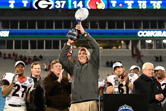 CHARLOTTE, NC - DECEMBER 30:  Head coach Mark Richt and the Georgia Bulldogs holds up the trophy after winning the Belk Bowl against the Louisville Cardinals at Bank of America Stadium on December 30, 2014 in Charlotte, North Carolina. Georgia won 37-14. 