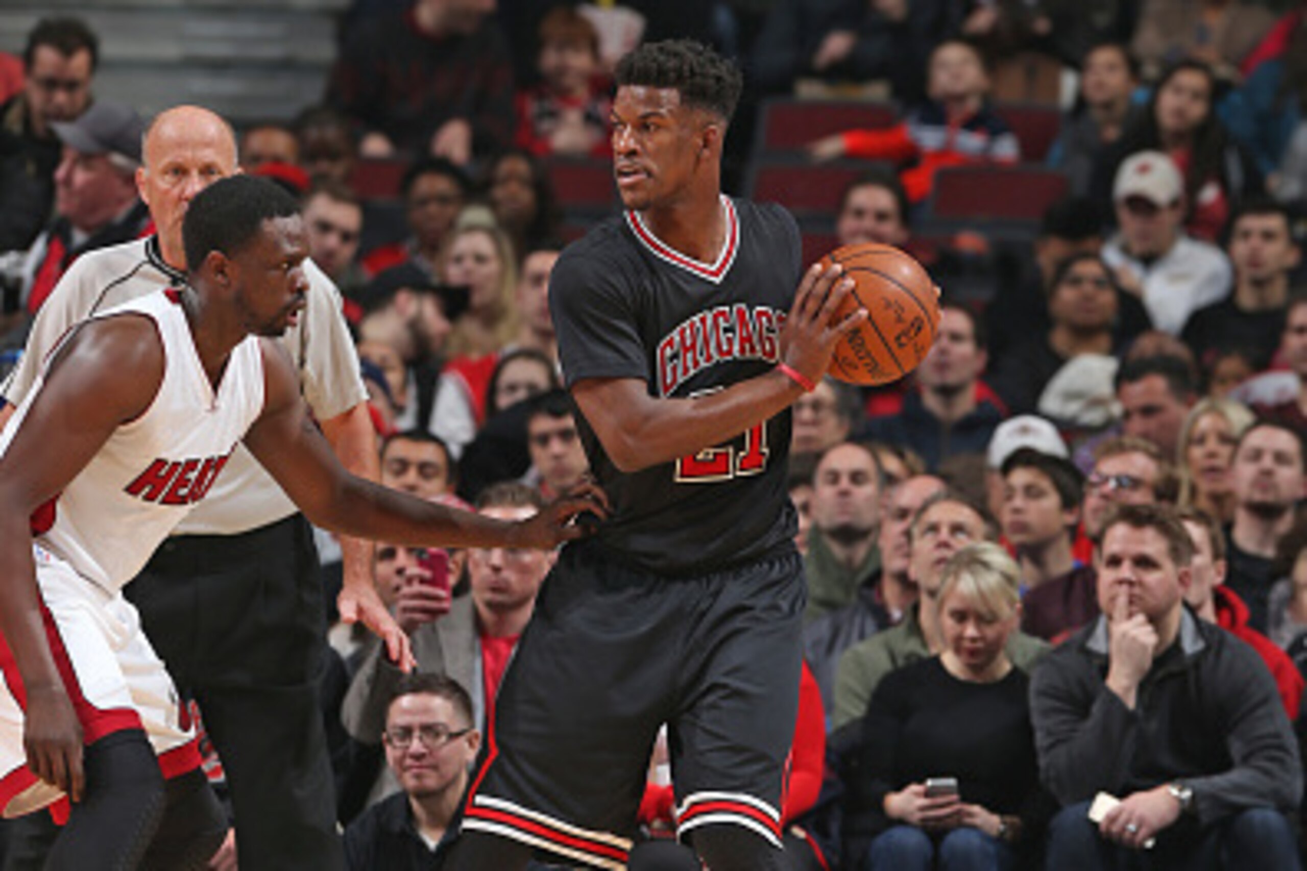 CHICAGO, IL - JANUARY 25:  Jimmy Butler #21 of the Chicago Bulls handles the ball against Luol Deng #9 of the Miami Heat during the game on January 25, 2015 at the United Center in Chicago, Illinois. NOTE TO USER: User expressly acknowledges and agrees th
