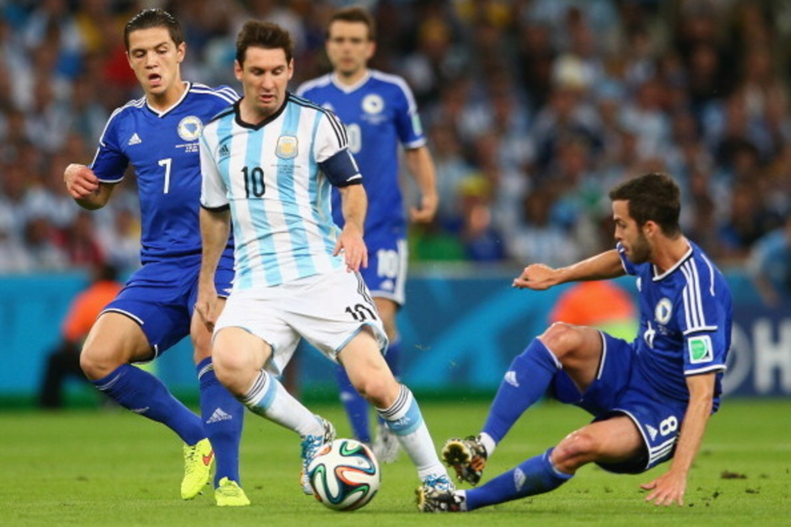 RIO DE JANEIRO, BRAZIL - JUNE 15:  Lionel Messi of Argentina controls the ball as Muhamed Besic and Miralem Pjanic  Bosnia and Herzegovina give chase during the 2014 FIFA World Cup Brazil Group F match between Argentina and Bosnia-Herzegovina at Maracana 