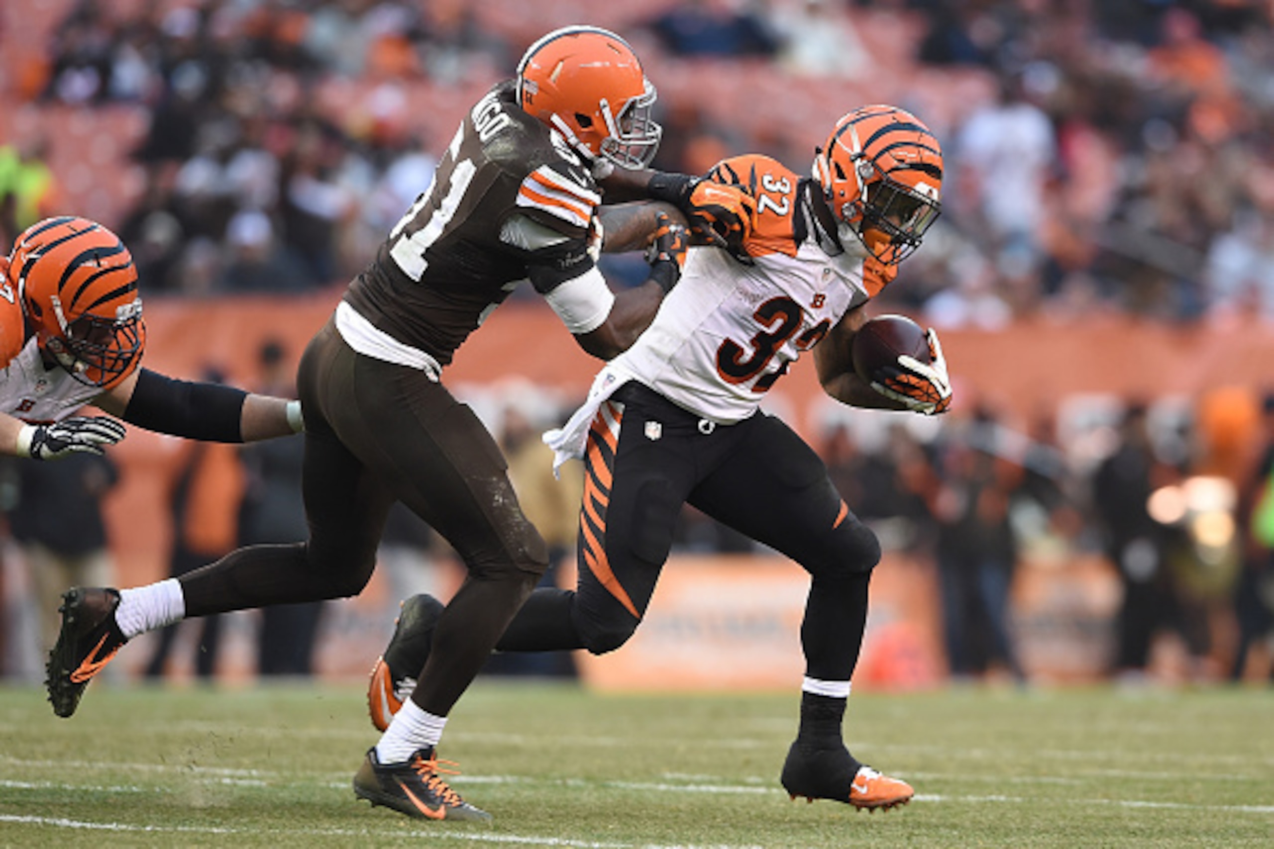 CLEVELAND, OH - DECEMBER 14:  Jeremy Hill #32 of the Cincinnati Bengals carries the ball past Barkevious Mingo #51 of the Cleveland Browns at FirstEnergy Stadium on December 14, 2014 in Cleveland, Ohio.  (Photo by Jason Miller/Getty Images)