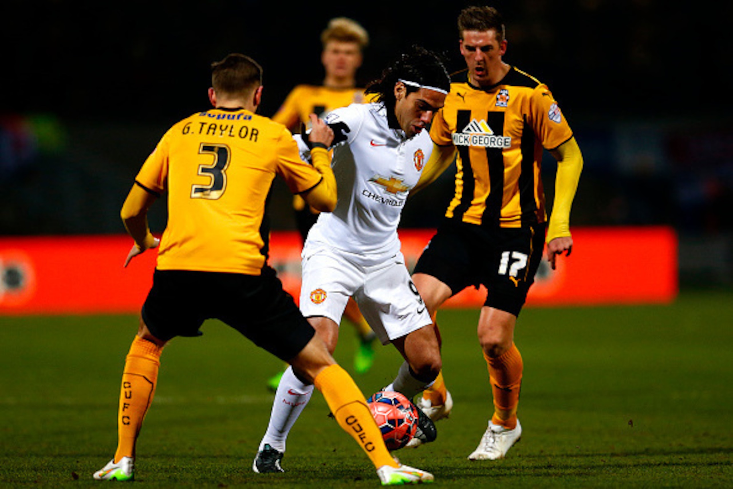 CAMBRIDGE, ENGLAND - JANUARY 23:  Radamel Falcao Garcia of Manchester United battles for the ball with Greg Taylor and Liam Hughes of Cambridge United during the FA Cup Fourth Round match between Cambridge United and Manchester United at The R Costings Ab