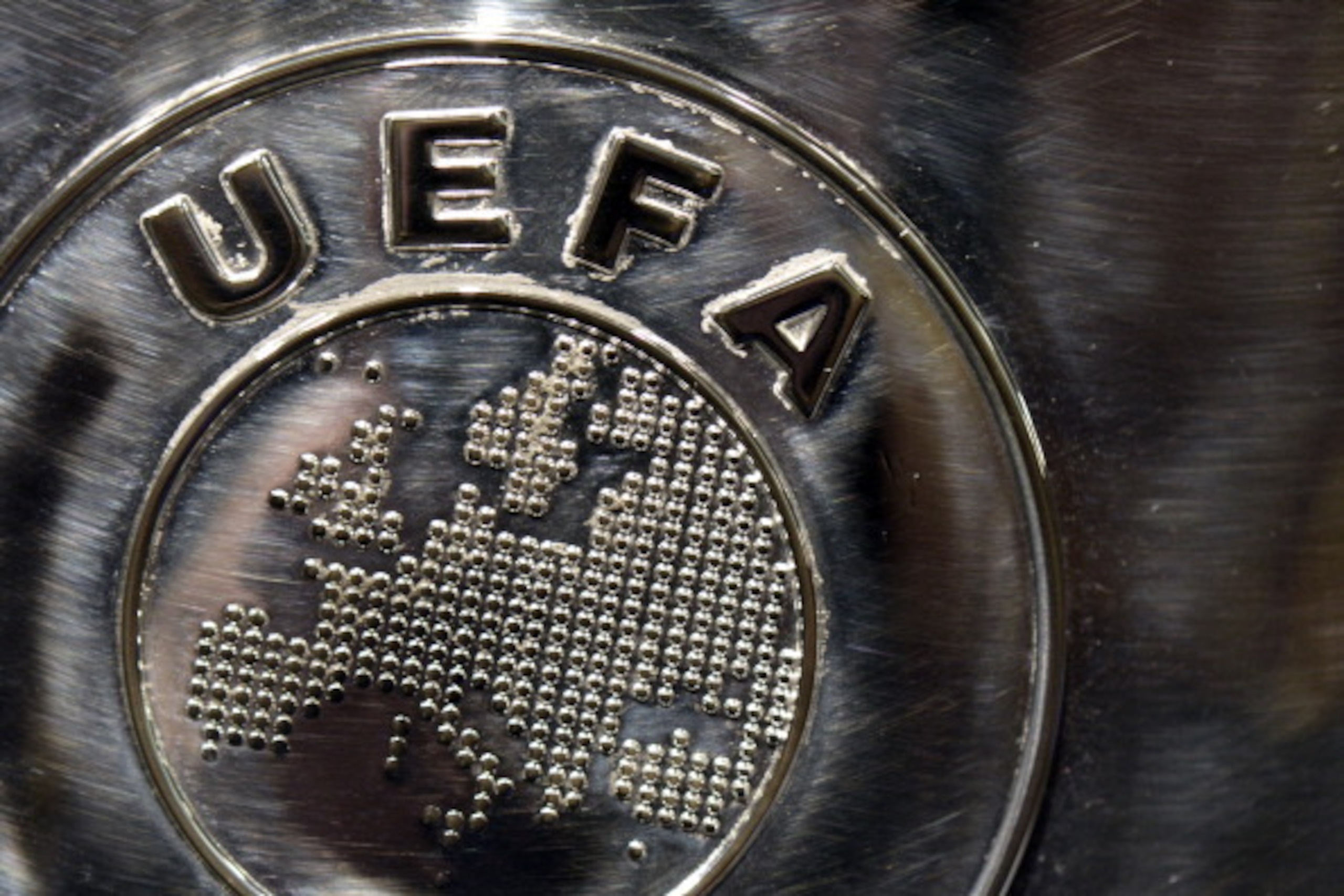 NYON, SWITZERLAND - JULY 18:  The UEFA logo is seen on the UEFA Champions League trophy as it is prepared for the UEFA 2014/15 Champions League third qualifying rounds draw at the UEFA headquarters, The House of European Football, on July 18, 2014 in Nyon