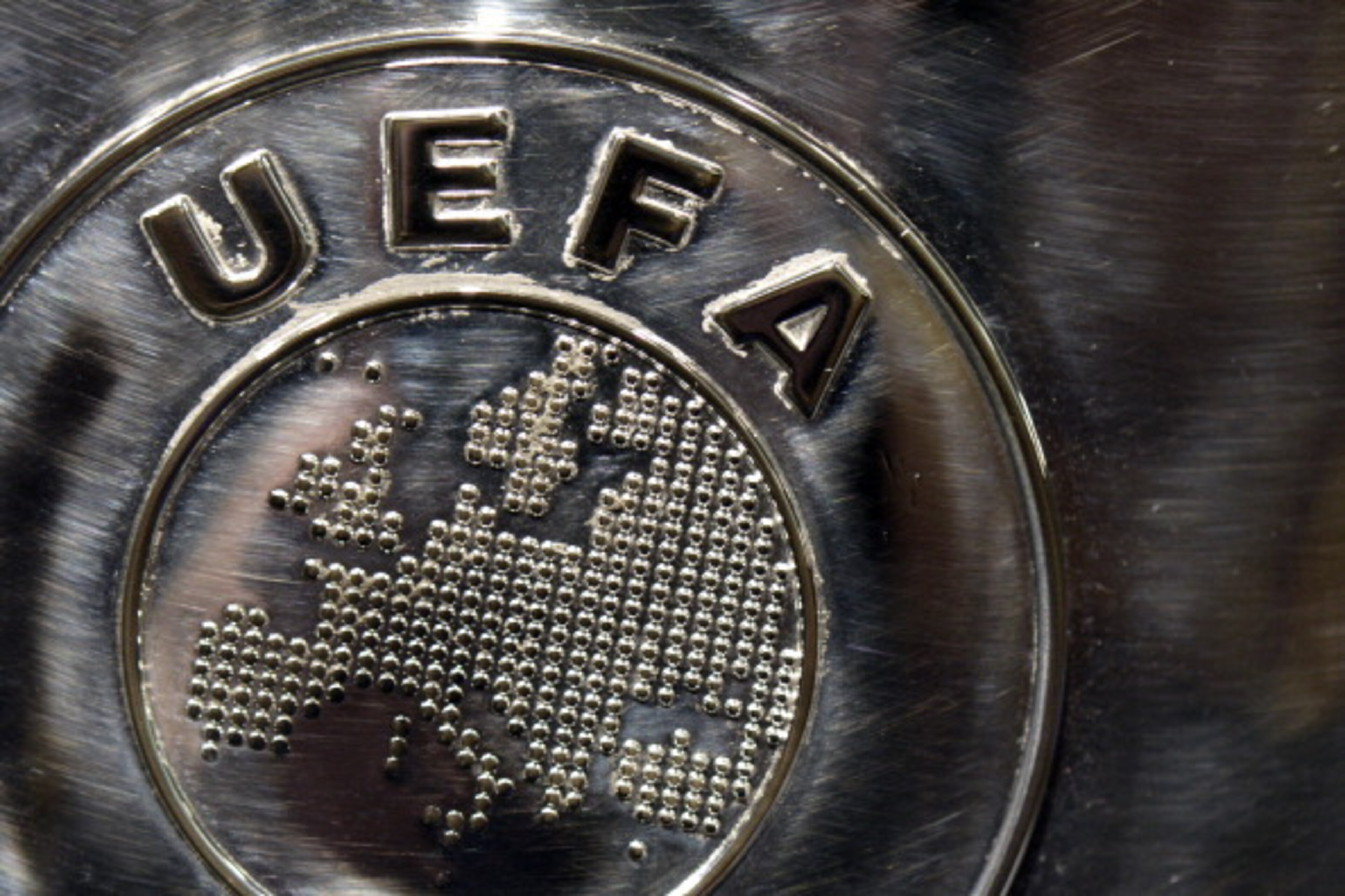 NYON, SWITZERLAND - JULY 18:  The UEFA logo is seen on the UEFA Champions League trophy as it is prepared for the UEFA 2014/15 Champions League third qualifying rounds draw at the UEFA headquarters, The House of European Football, on July 18, 2014 in Nyon
