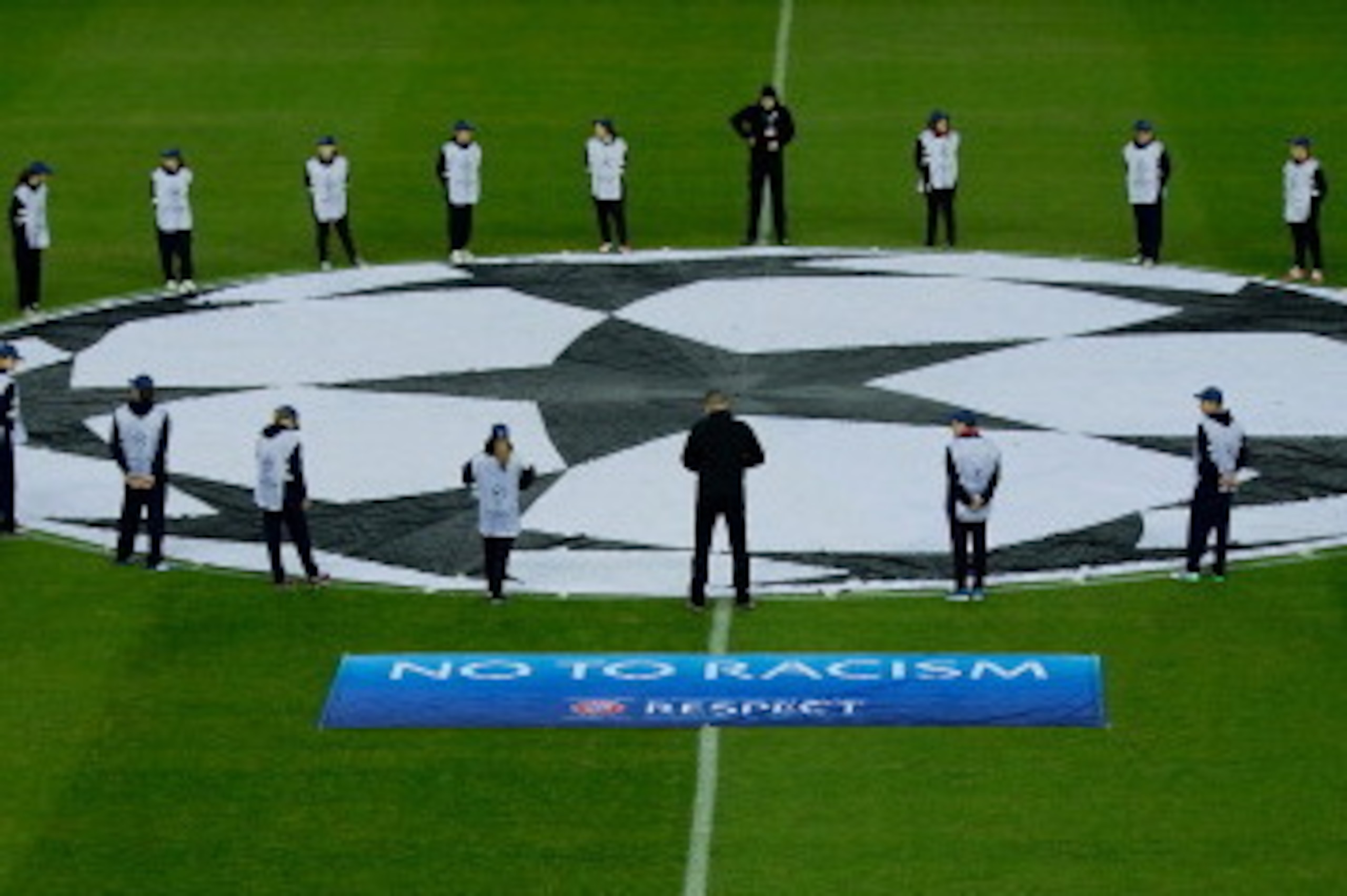 MADRID, SPAIN - DECEMBER 11: UEFA staff with  signs paying tribute to Nelson Mandela and against racism prior to start the UEFA Champions League Group G match at Vicente Calderon Stadium on December 11, 2013 in Madrid, Spain.  (Photo by Gonzalo Arroyo Mor