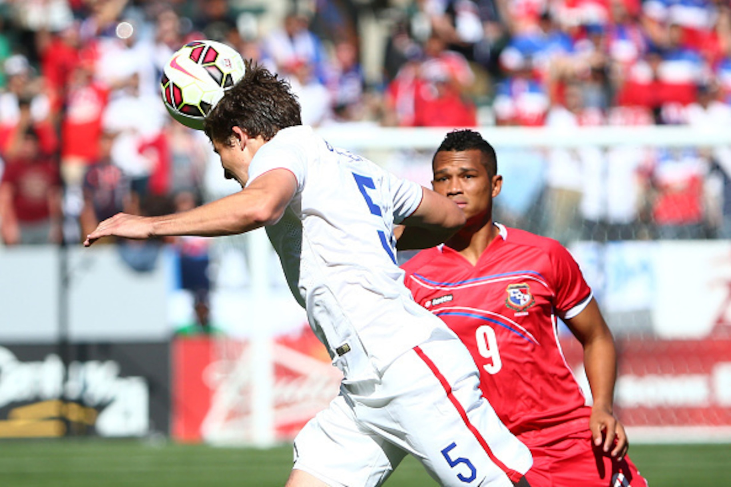 LOS ANGELES, CA - FEBRUARY 08:  Matt Besler #5 of the USA heads the ball clear under pressure from Rolando Blackburn #9 of Panama in the first half during the international men's friendly match at StubHub Center on February 8, 2015 in Los Angeles, Califor