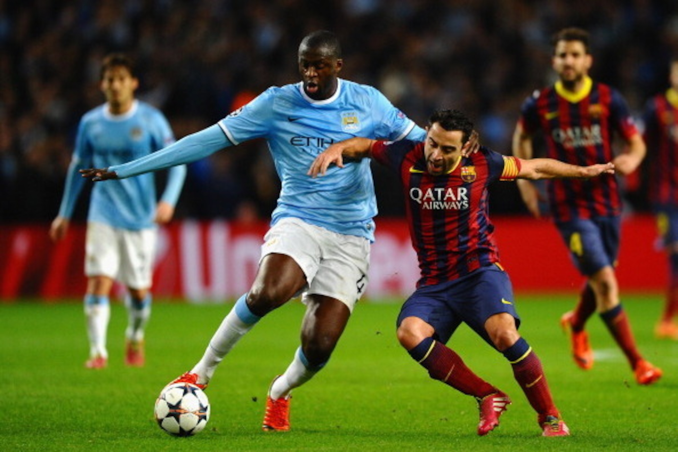 MANCHESTER, ENGLAND - FEBRUARY 18: Xavi Hernandez of Barcelona battles with Yaya Toure of Manchester City during the UEFA Champions League Round of 16 first leg match between Manchester City and Barcelona at the Etihad Stadium on February 18, 2014 in Man MANCHESTER, ENGLAND - FEBRUARY 18: Xavi Hernandez of Barcelona battles with Yaya Toure of Manchester City during the UEFA Champions League Round of 16 first leg match between Manchester City and Barcelona at the Etihad Stadium on February 18, 2014 in Man
