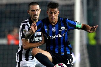 BERGAMO, ITALY - SEPTEMBER 27:  German Gustavo Denis (R) of Atalanta BC competes for the ball with Leonardo Bonucci (L) of Juventus FC during the Serie A match between Atalanta BC v Juventus FC at Stadio Atleti Azzurri d'Italia on September 27, 2014 in Be
