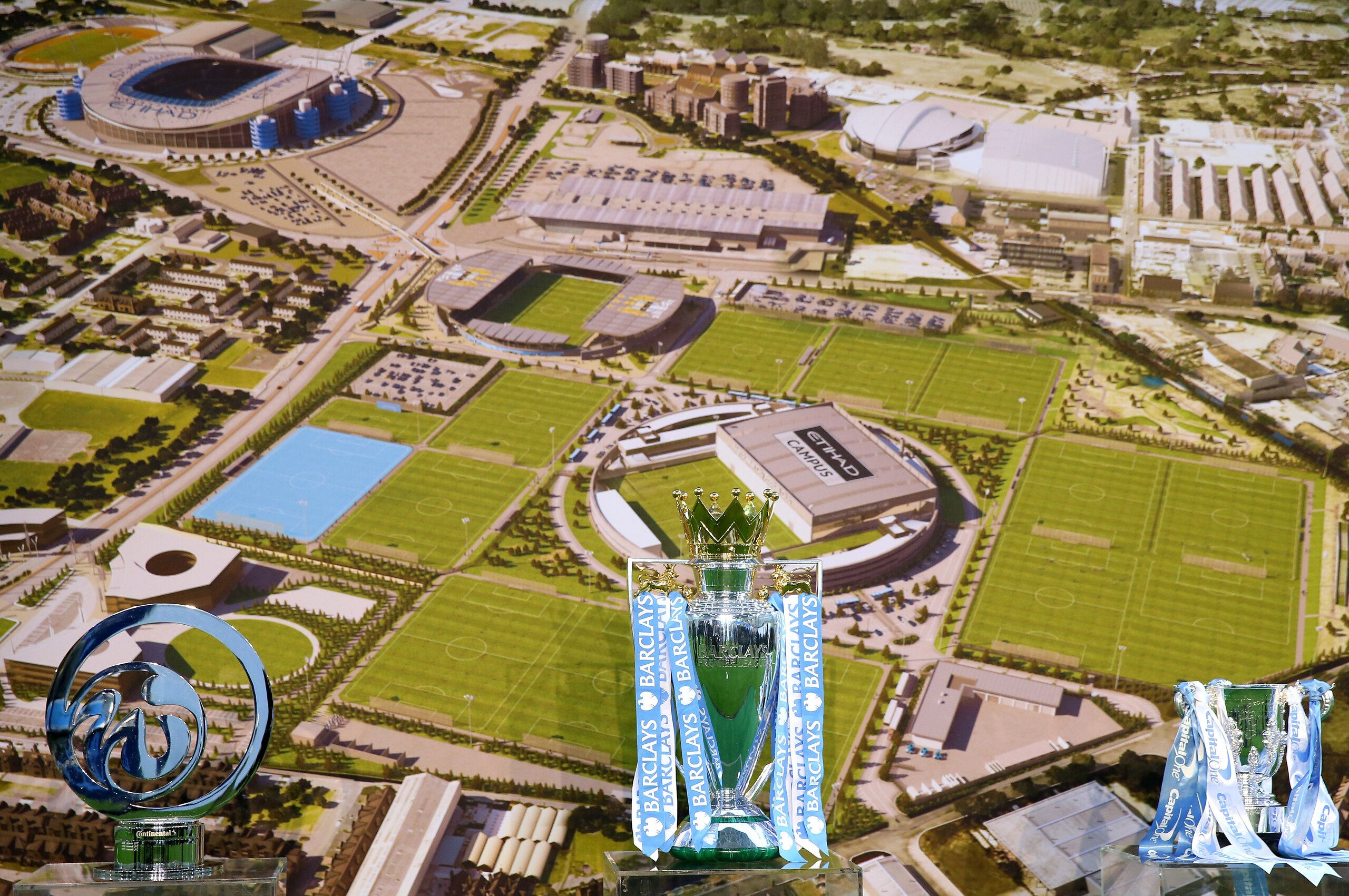 MANCHESTER, ENGLAND - DECEMBER 08:  Trophies sit in front of an aerial photograph during the official launch of the Manchester City Football Academy at the City Football Academy on December 8, 2014 in Manchester, United Kingdom.  (Photo by Alex Livesey/Ge