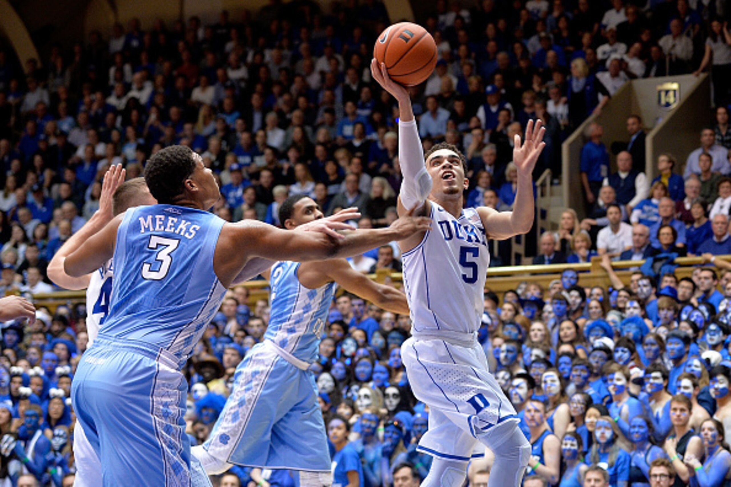 DURHAM, NC - FEBRUARY 18:  Tyus Jones #5 of the Duke Blue Devils drives between Kennedy Meeks #3 and Joel Berry II #2 of the North Carolina Tar Heels during their game at Cameron Indoor Stadium on February 18, 2015 in Durham, North Carolina.  (Photo by Gr