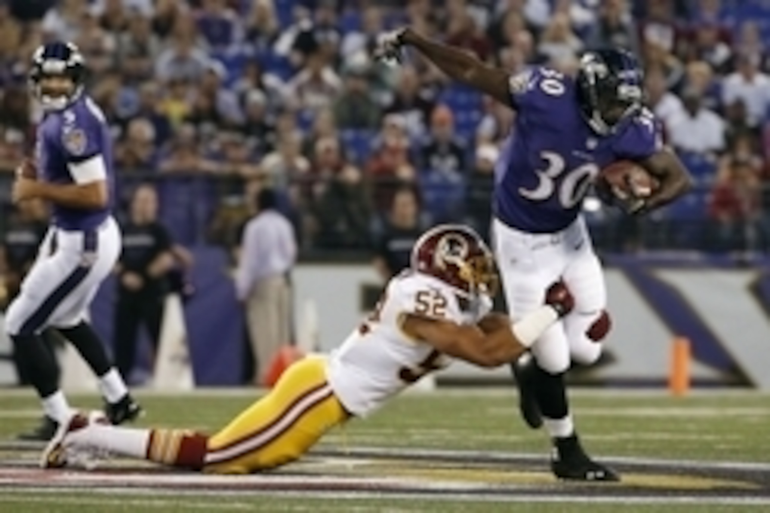 Aug 23, 2014; Baltimore, MD, USA; Baltimore Ravens running back Bernard Pierce (30) carries the ball as Washington Redskins linebacker Keenan Robinson (52) tackles in the first quarter at M&T Bank Stadium. Mandatory Credit: Amber Searls-USA TODAY Sports