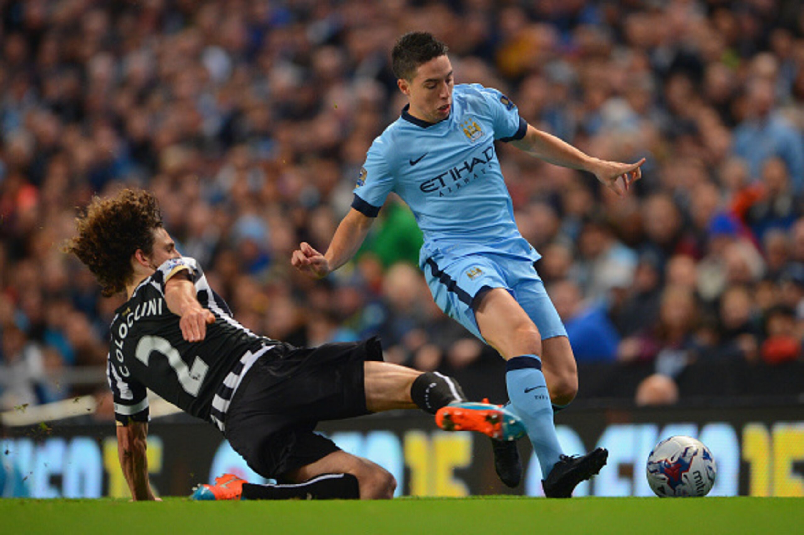 MANCHESTER, ENGLAND - OCTOBER 29:  Fabricio Coloccini of Newcastle United slides in to tackle Samir Nasri of Manchester City during the Capital One Cup Fourth Round match between Manchester City and Newcastle United at Etihad Stadium on October 29, 2014 i