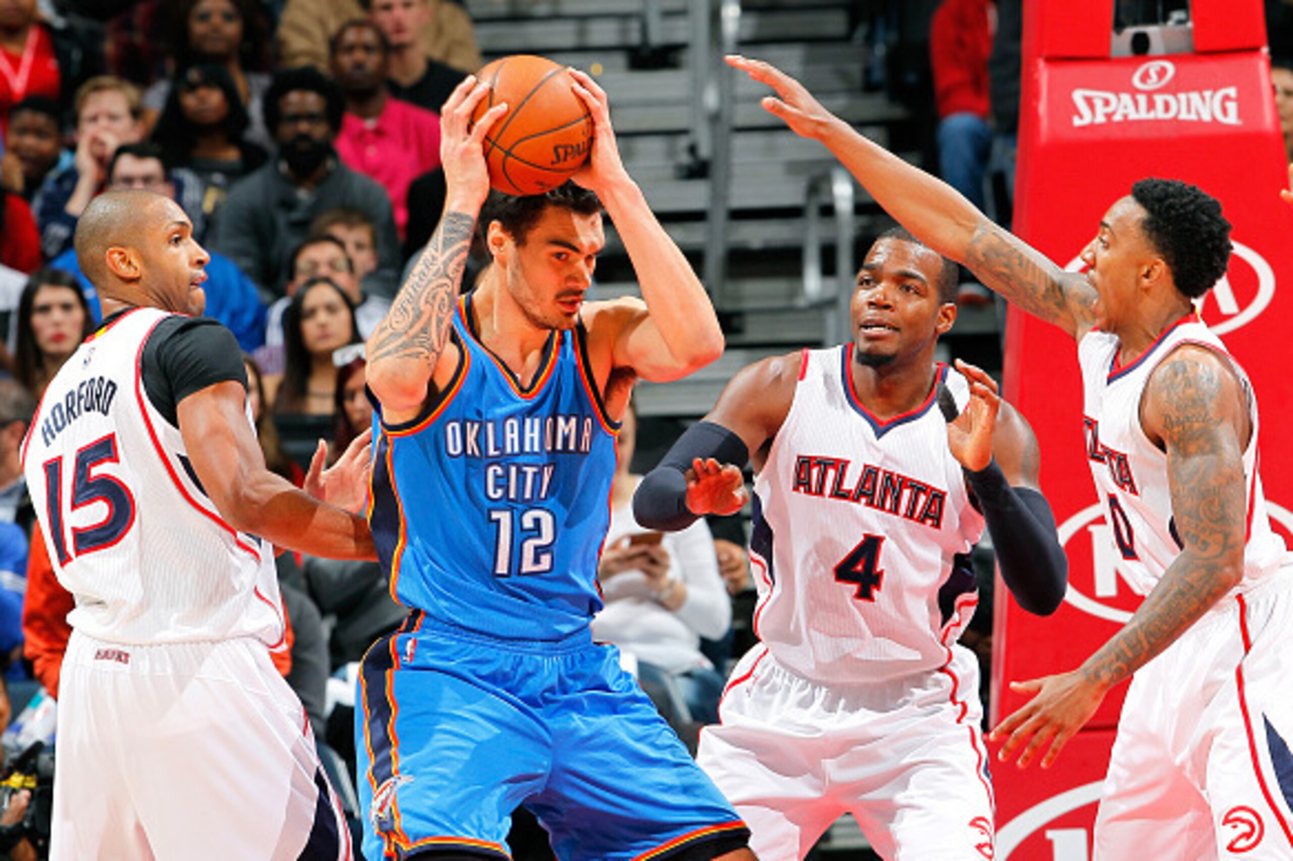 ATLANTA, GA - JANUARY 23:  Steven Adams #12 of the Oklahoma City Thunder grabs a rebound against Al Horford #15, Paul Millsap, and Jeff Teague #0 of the Atlanta Hawks at Philips Arena on January 23, 2015 in Atlanta, Georgia.  NOTE TO USER: User expressly 