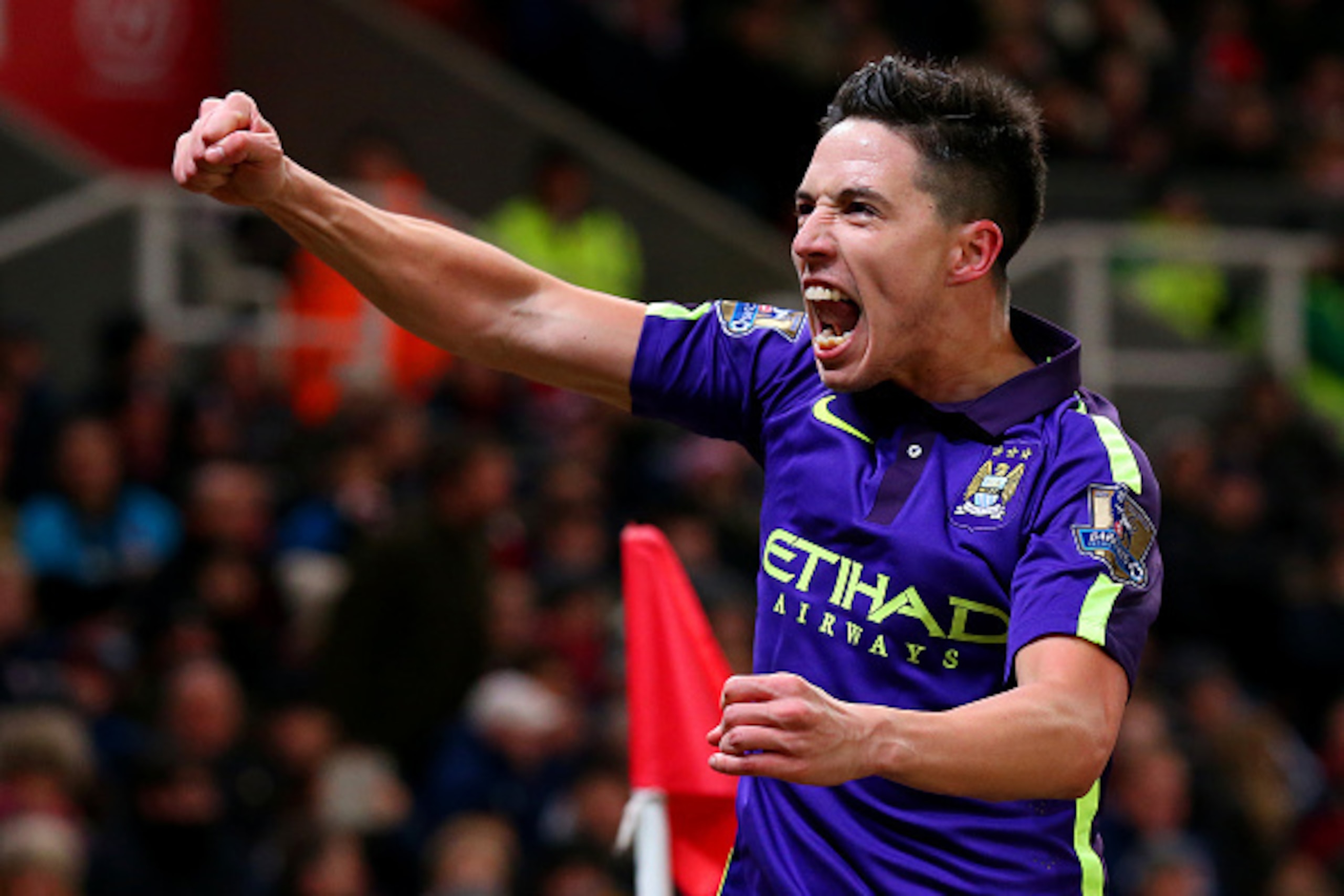 STOKE ON TRENT, ENGLAND - FEBRUARY 11:  Samir Nasri of Manchester City celebrates after team-mate James Milner scored their second goal during the Barclays Premier League match between Stoke City and Manchester City at Britannia Stadium on February 11, 20