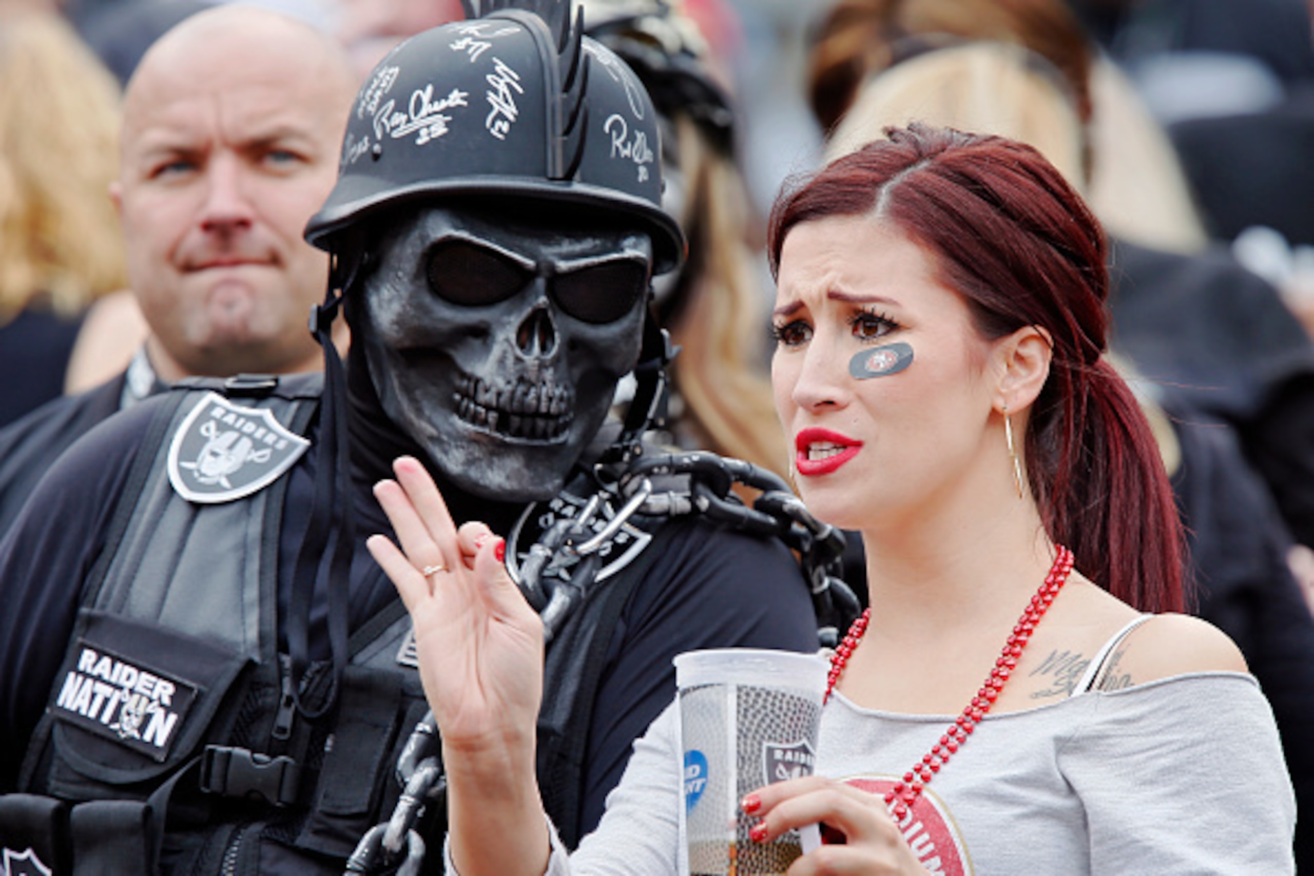 OAKLAND, CA - DECEMBER 7:  An Oakland Raiders fan and a San Francisco 49ers fan watch their teams play each other on December 7, 2014 at O.co Coliseum in Oakland, California.  The Raiders won 24-13.  (Photo by Brian Bahr/Getty Images)