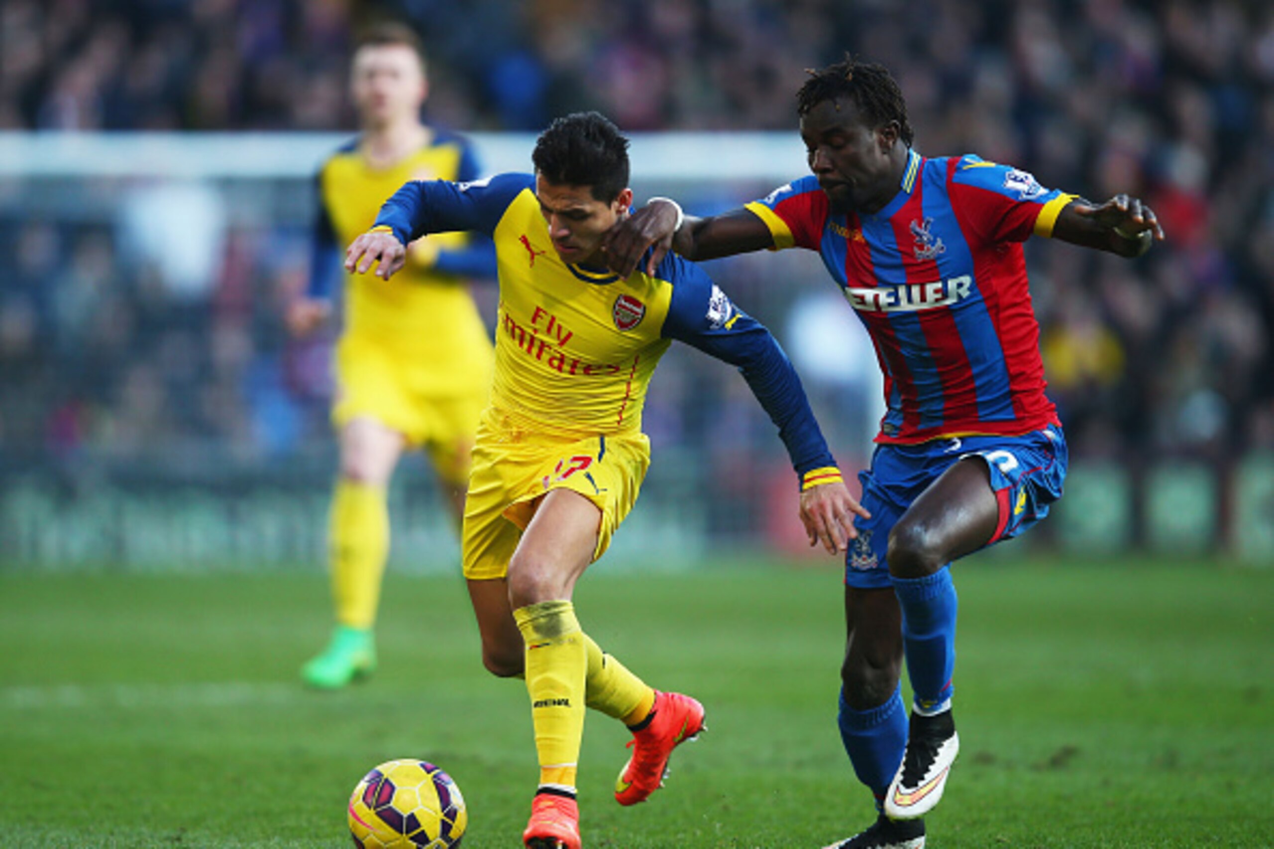 LONDON, ENGLAND - FEBRUARY 21:  Pape N'Diaye Souare of Crystal Palace challenges Alexis Sanchez of Arsenal during the Barclays Premier League match between Crystal Palace and Arsenal at Selhurst Park on February 21, 2015 in London, England.  (Photo by Cli