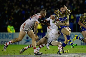 WARRINGTON, ENGLAND - FEBRUARY 20:  Daryl Clark of Warrington Wolves is tackled by Josh Dugan of St George Illawarra Dragons during the World Club Series match between Warrington Wolves and St George Illawarra Dragons at The Halliwell Jones Stadium on Feb