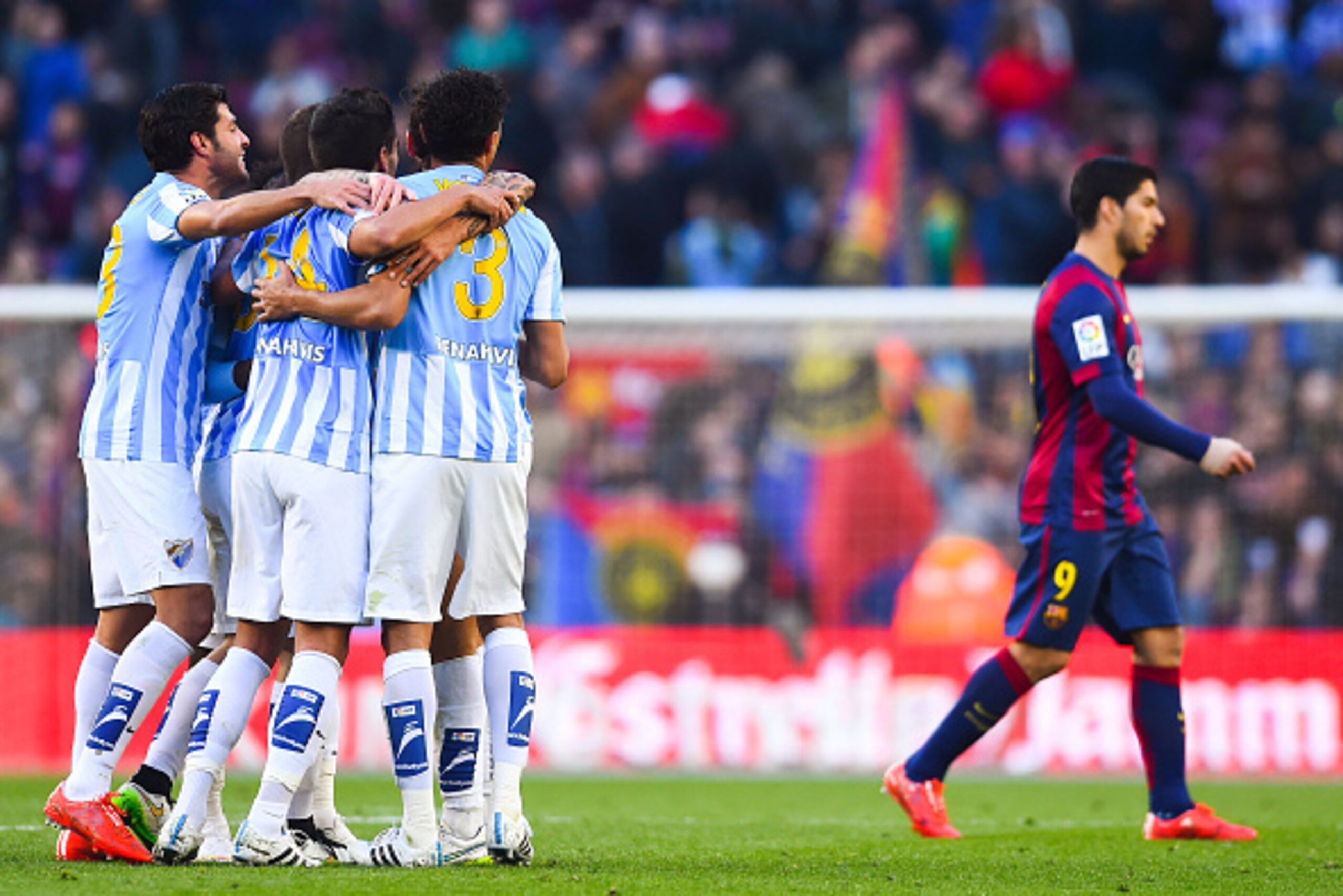 BARCELONA, SPAIN - FEBRUARY 21:  Luis Suarez of FC Barcelona leaves the pitch as Malaga CF players celebrate the victory at the end of the La Liga match between FC Barcelona and Malaga CF at Camp Nou on February 21, 2015 in Barcelona, Spain.  (Photo by Da