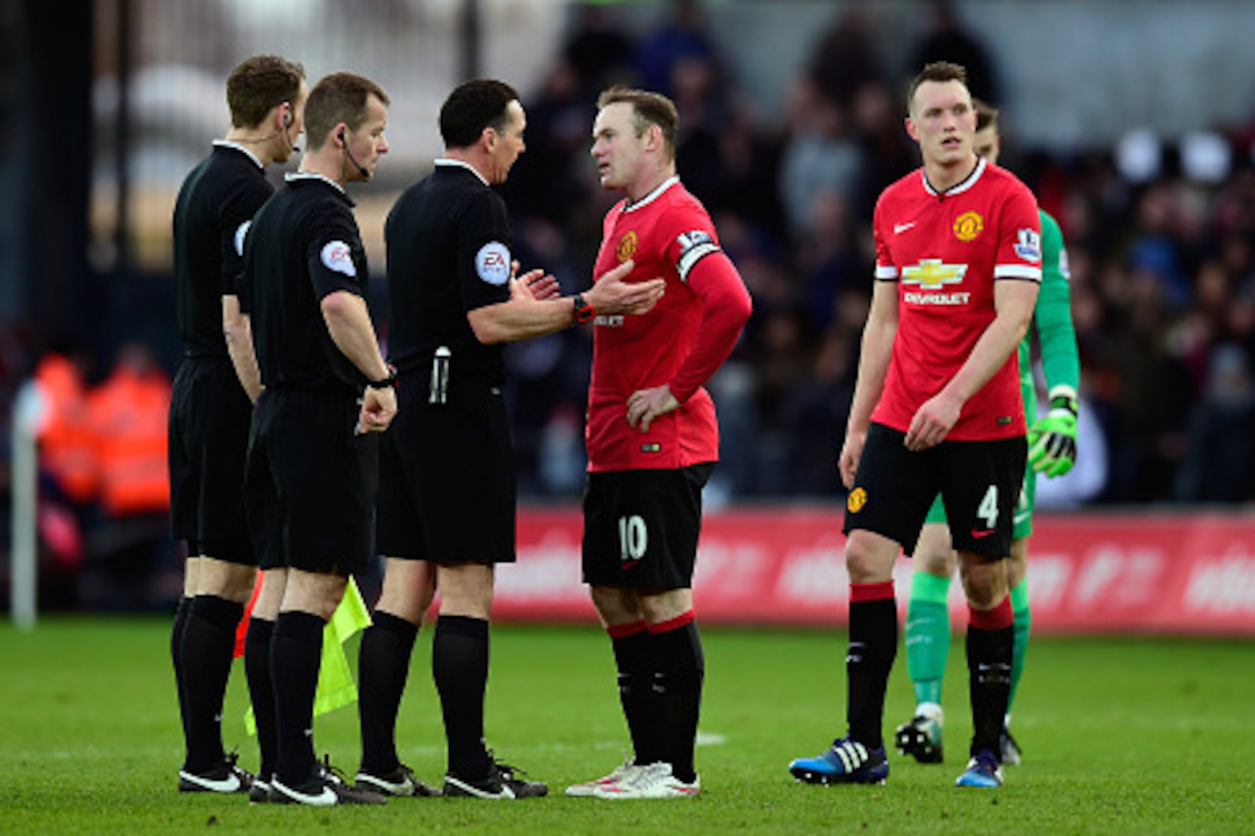 SWANSEA, WALES - FEBRUARY 21:  Manchester United player Wayne Rooney confronts referee Neil Swarbrick during the Barclays Premier League match between Swansea City and Manchester United at Liberty Stadium on February 21, 2015 in Swansea, Wales.  (Photo by