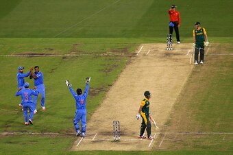 MELBOURNE, AUSTRALIA - FEBRUARY 22:  Ravichandran Ashwin of India is congratulated by team mates after taking the wicket of JP Duminy of South Africa during the 2015 ICC Cricket World Cup match between South Africa and India at Melbourne Cricket Ground on