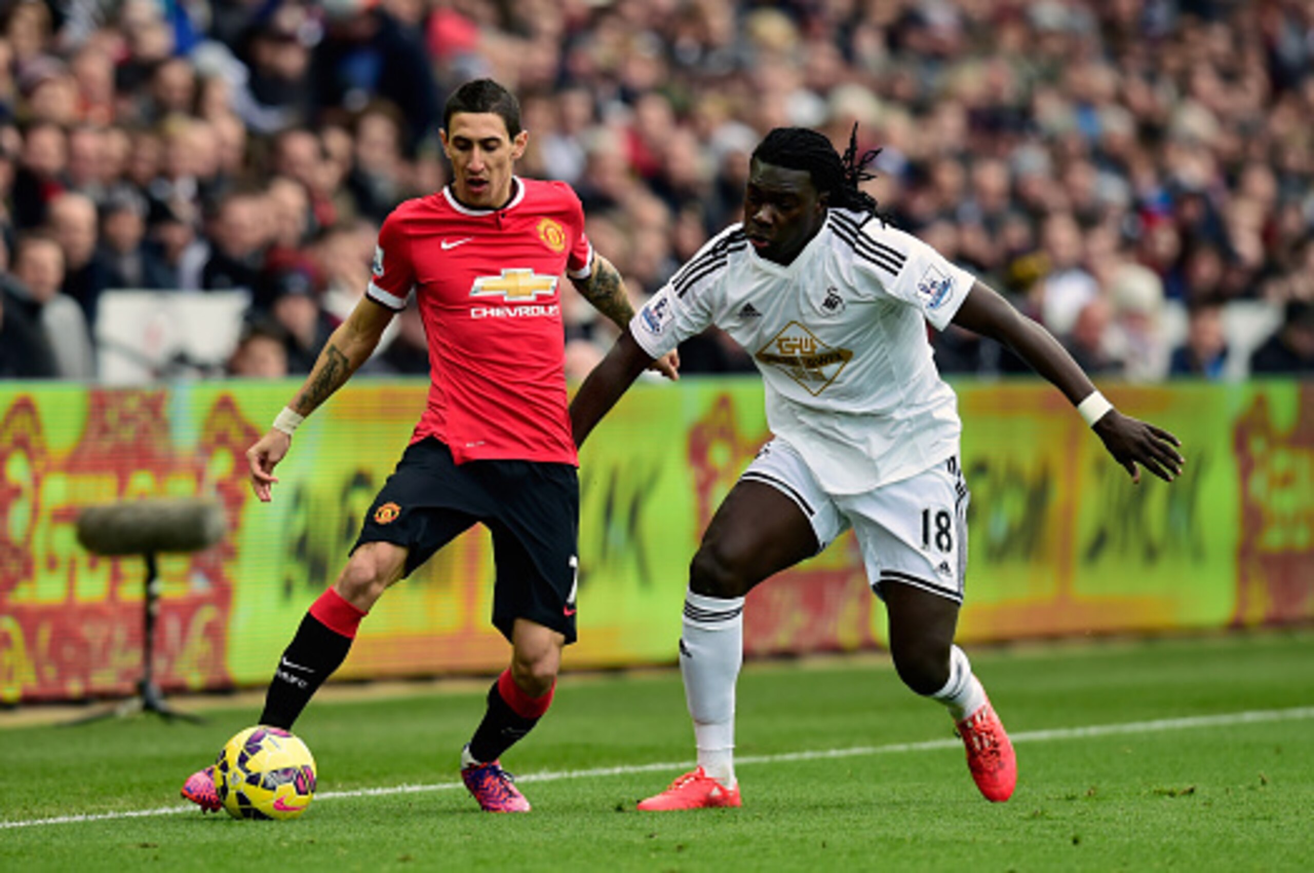 SWANSEA, WALES - FEBRUARY 21: Angel Di Maria of Manchester United challenges Bafetimbi Gomis of Swansea (r) during the Barclays Premier League match between Swansea City and Manchester United at Liberty Stadium on February 21, 2015 in Swansea, Wales.  (Ph