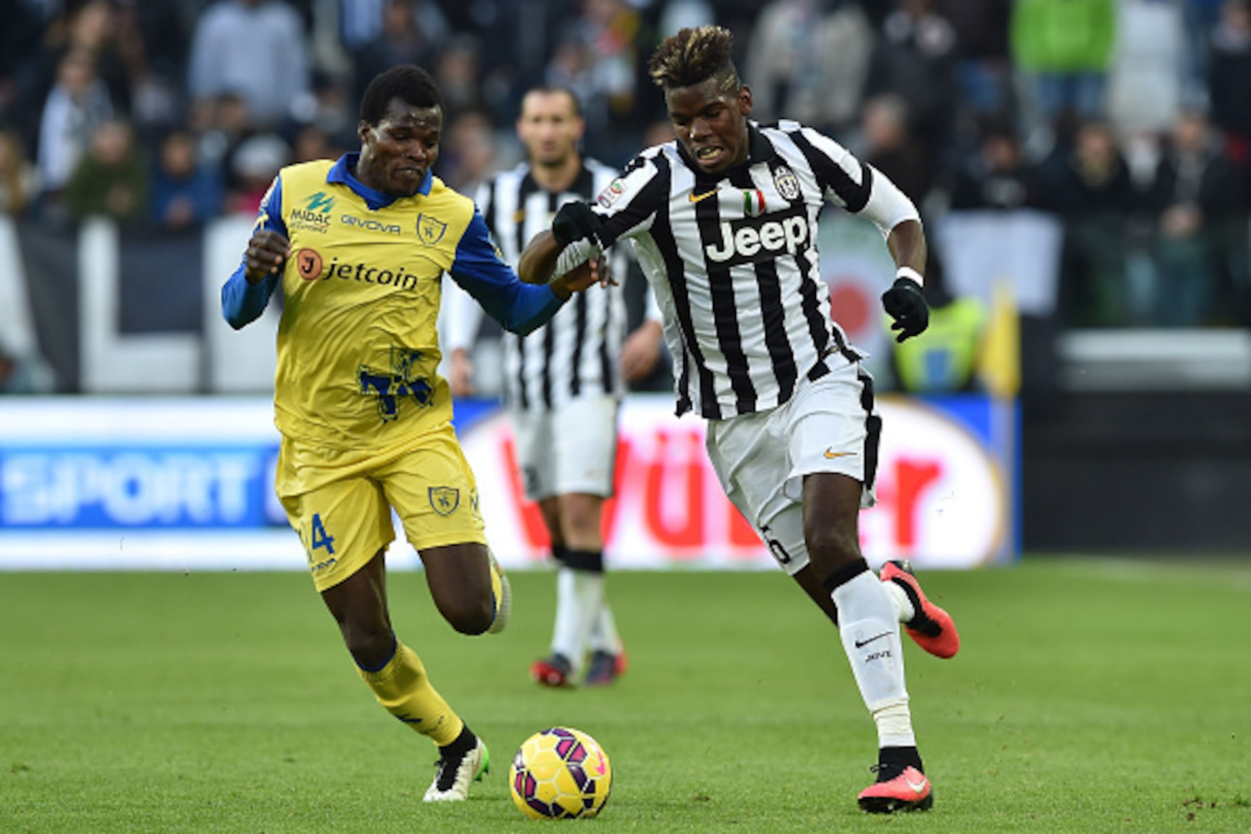 TURIN, ITALY - JANUARY 25:  Paul Pogba (R) of Juventus FC in action against Isaac Cofie of AC Chievo Verona during the Serie A match between Juventus FC and AC Chievo Verona at Juventus Arena on January 25, 2015 in Turin, Italy.  (Photo by Valerio Pennici