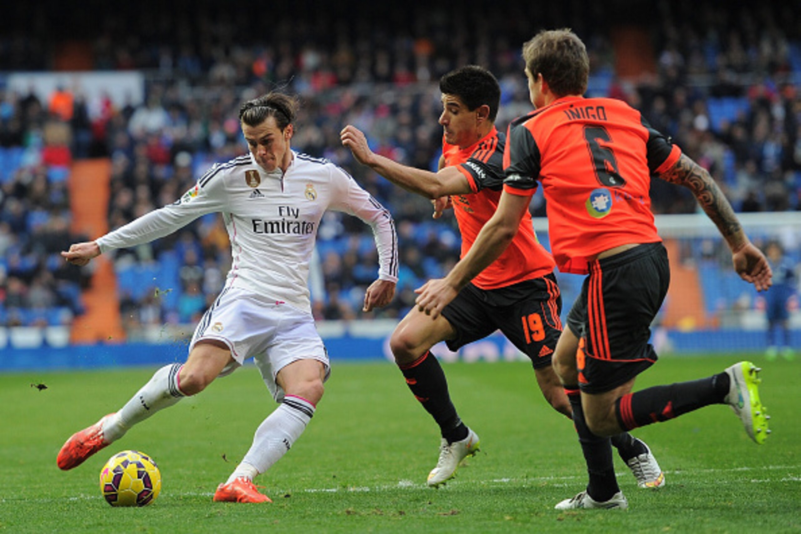 MADRID, SPAIN - JANUARY 31:  Gareth Bale of Real Madrid shoots past Yuri Berchiche (#19) and Inigo Martinez of Real Sociedad de Futbol  complains to the linesman during the La Liga match between Real Madrid CF and Real Sociedad de Futbol at Estadio Santia